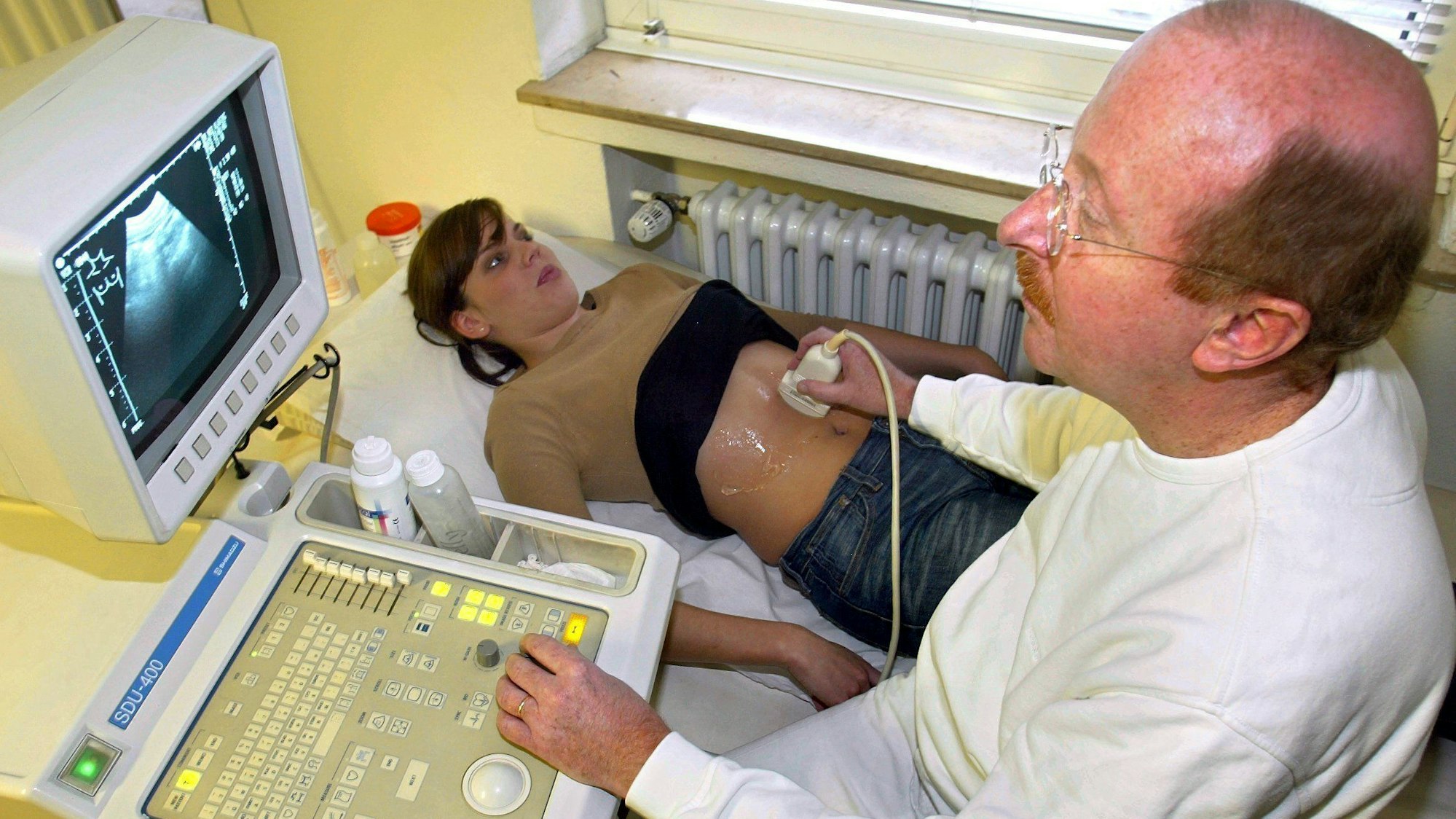 Ein Arzt macht eine Ultraschall-Untersuchung bei einer Patientin (Archivbild).
