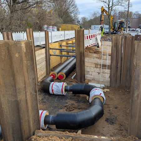 Das Foto zeigt eine Baugrube, in der sich neue Fernwärmerohre befinden.