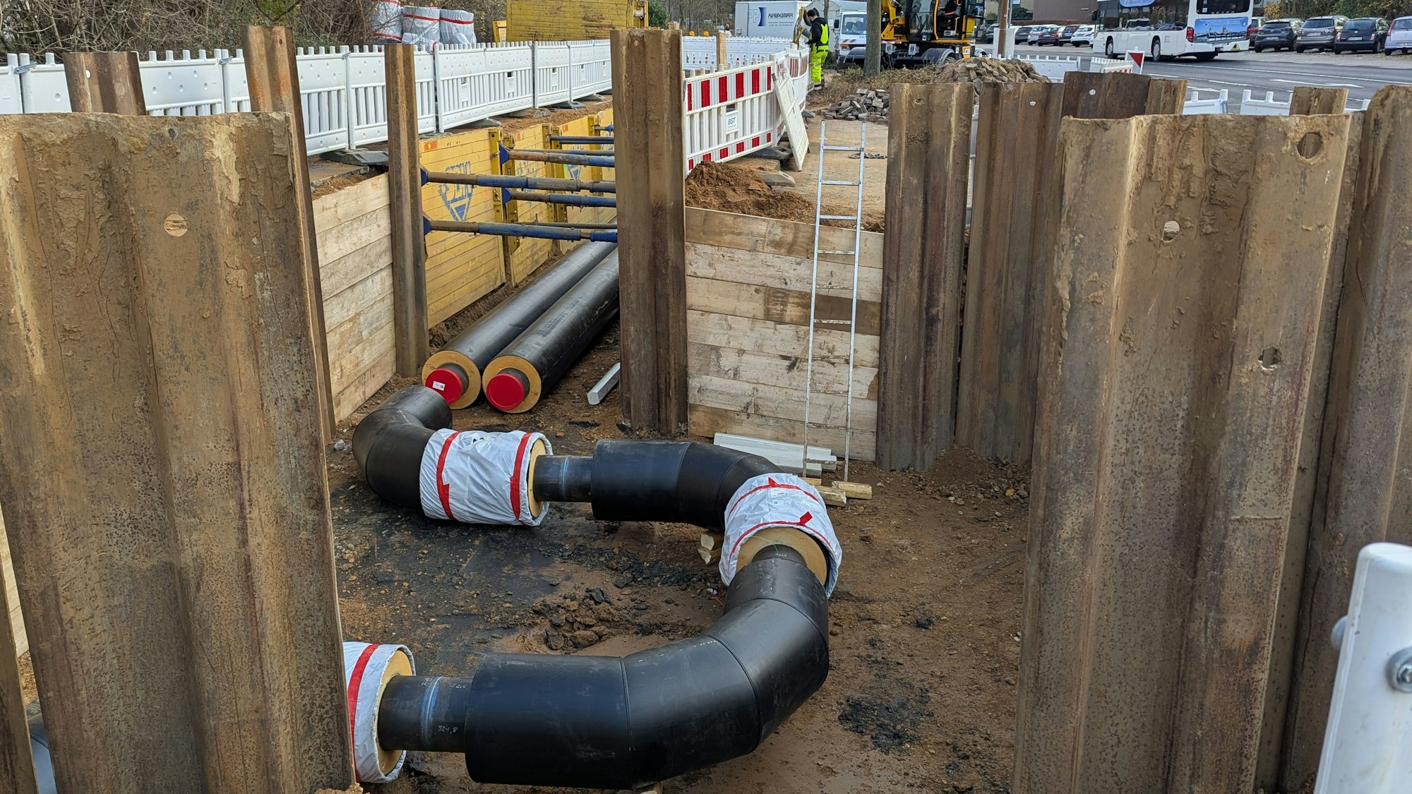 Das Foto zeigt Rohrleitungsstücke in einer Baugrube.