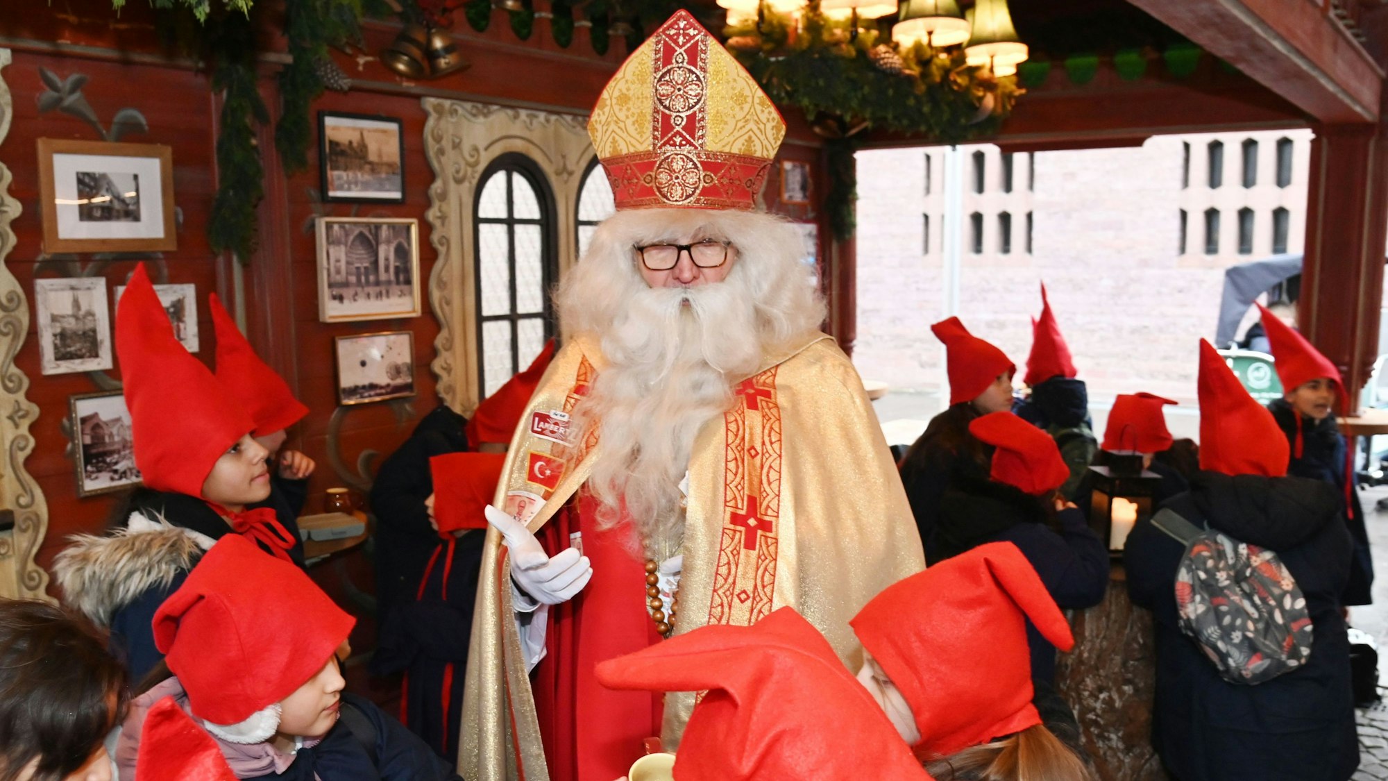 Wolfgang Kimmig-Liebe steht zwischen Kindern mit roten Mützen.