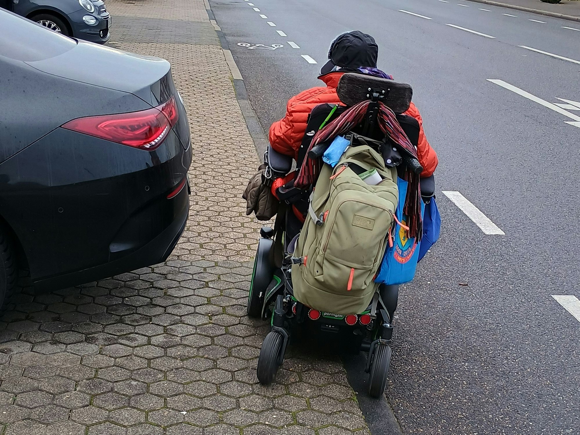 Weiland muss einem parkenden Auto auf dem Gehweh ausweichen und kommt dabei dem Radweg auf der Straße gefährlich nahe.