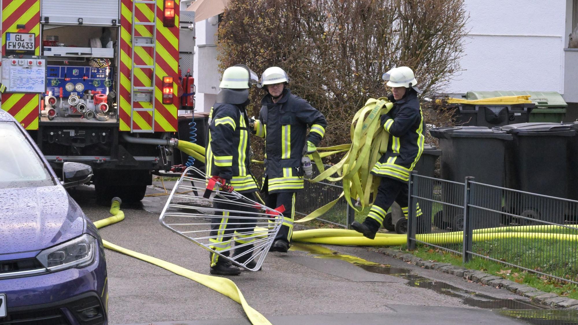 Feuerwehrleute sammeln Schläuche ein.