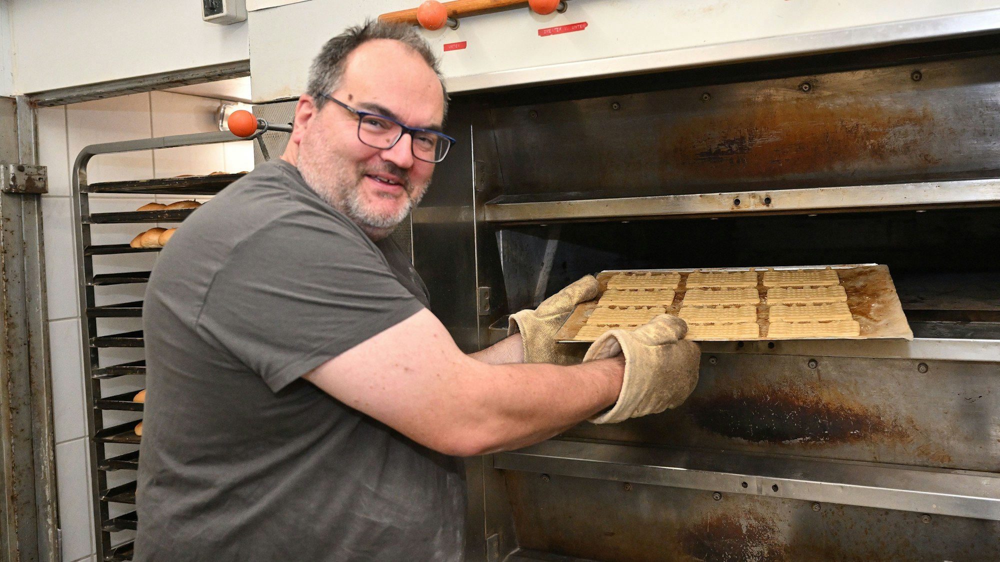 Mario Fritzen schiebt ein Blech mit Benefiz-Spekulatius in den Ofen seiner Kürtener Landbäckerei.