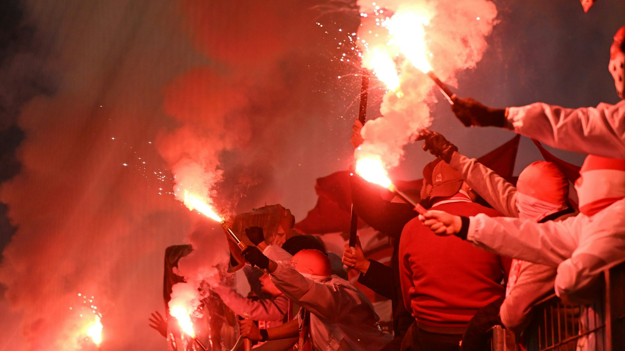 Die Ultras vermummten sich unter einer Blockfahne, um einer Strafverfolgung zu entgehen.