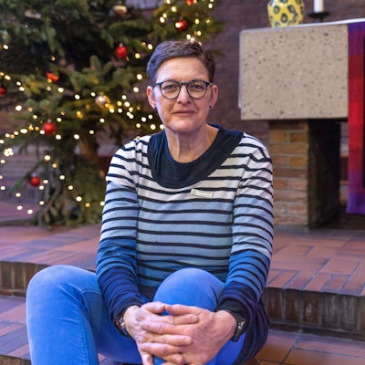 Dorothee Wortelkamp-M'Baye sitzt auf einer Treppenstufe vor dem Altar der Gefängniskirche.