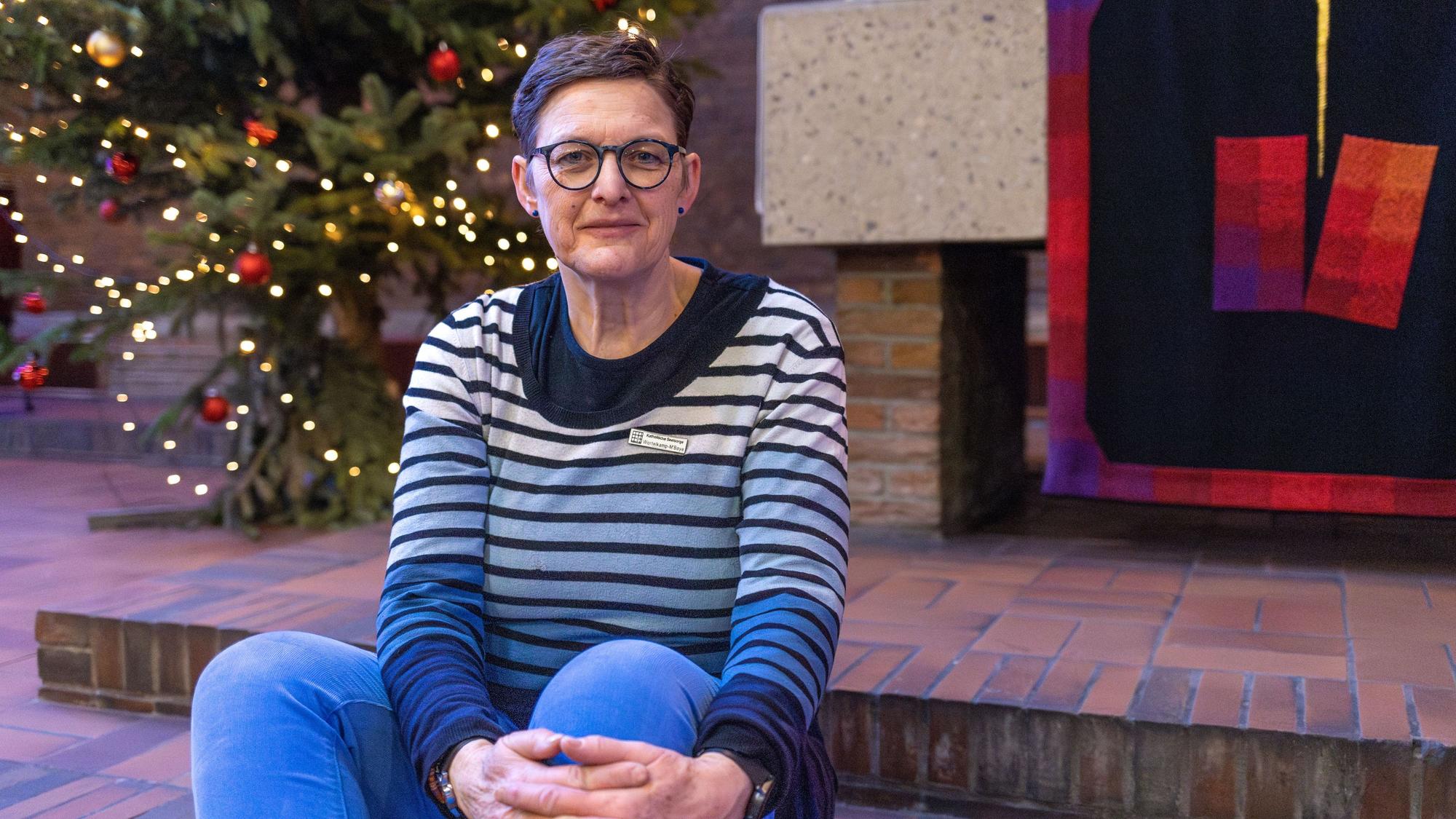 Dorothee Wortelkamp-M'Baye sitzt auf einer Treppenstufe vor dem Altar der Gefängniskirche.
