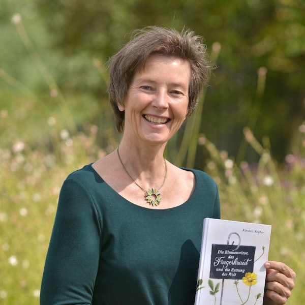 Eine lächelnde Frau in der Natur.