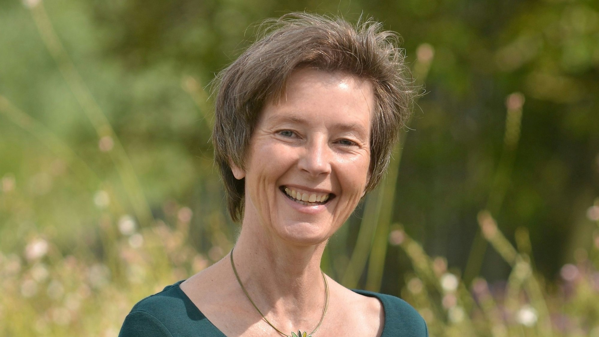 Eine lächelnde Frau in der Natur.