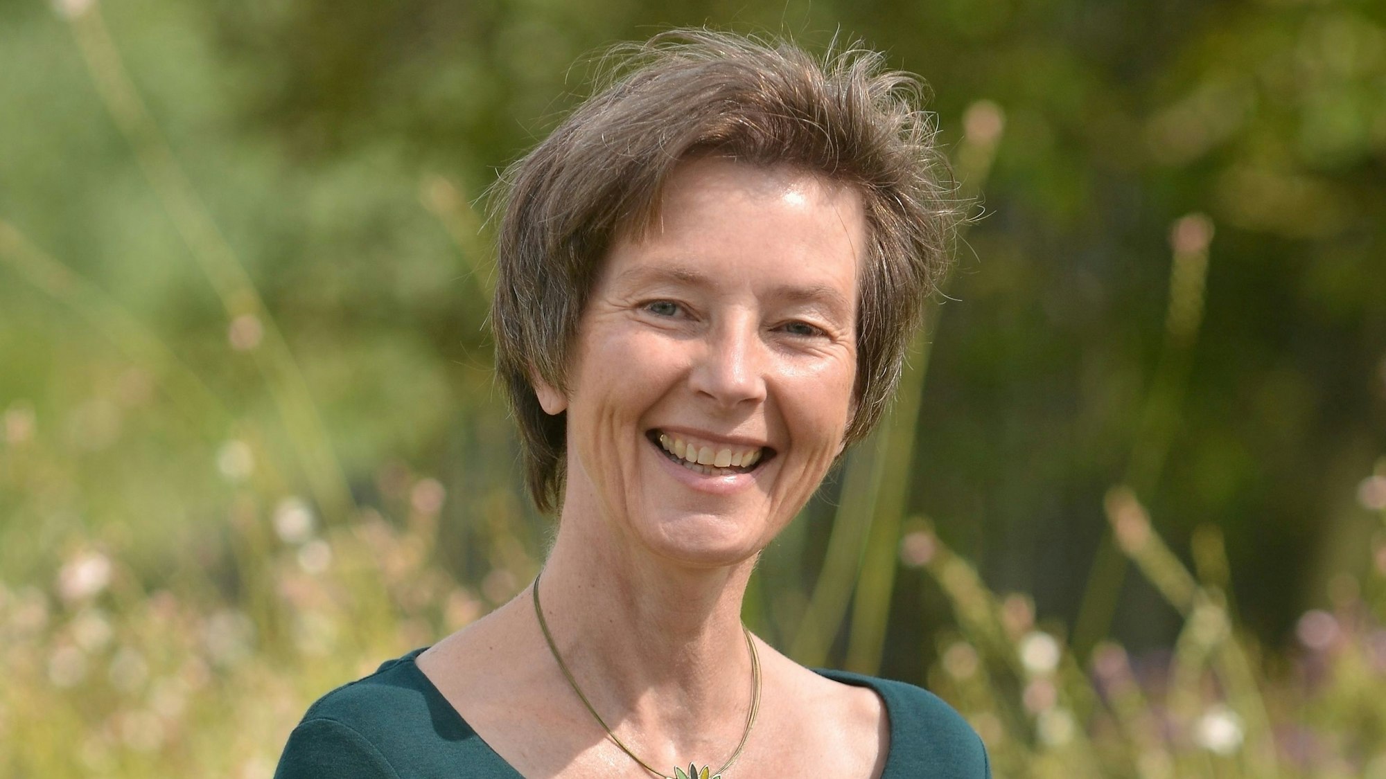 Eine lächelnde Frau in der Natur.