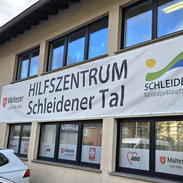 Blick auf das Hilfszentrum, an dem ein großes Transparent hängt.