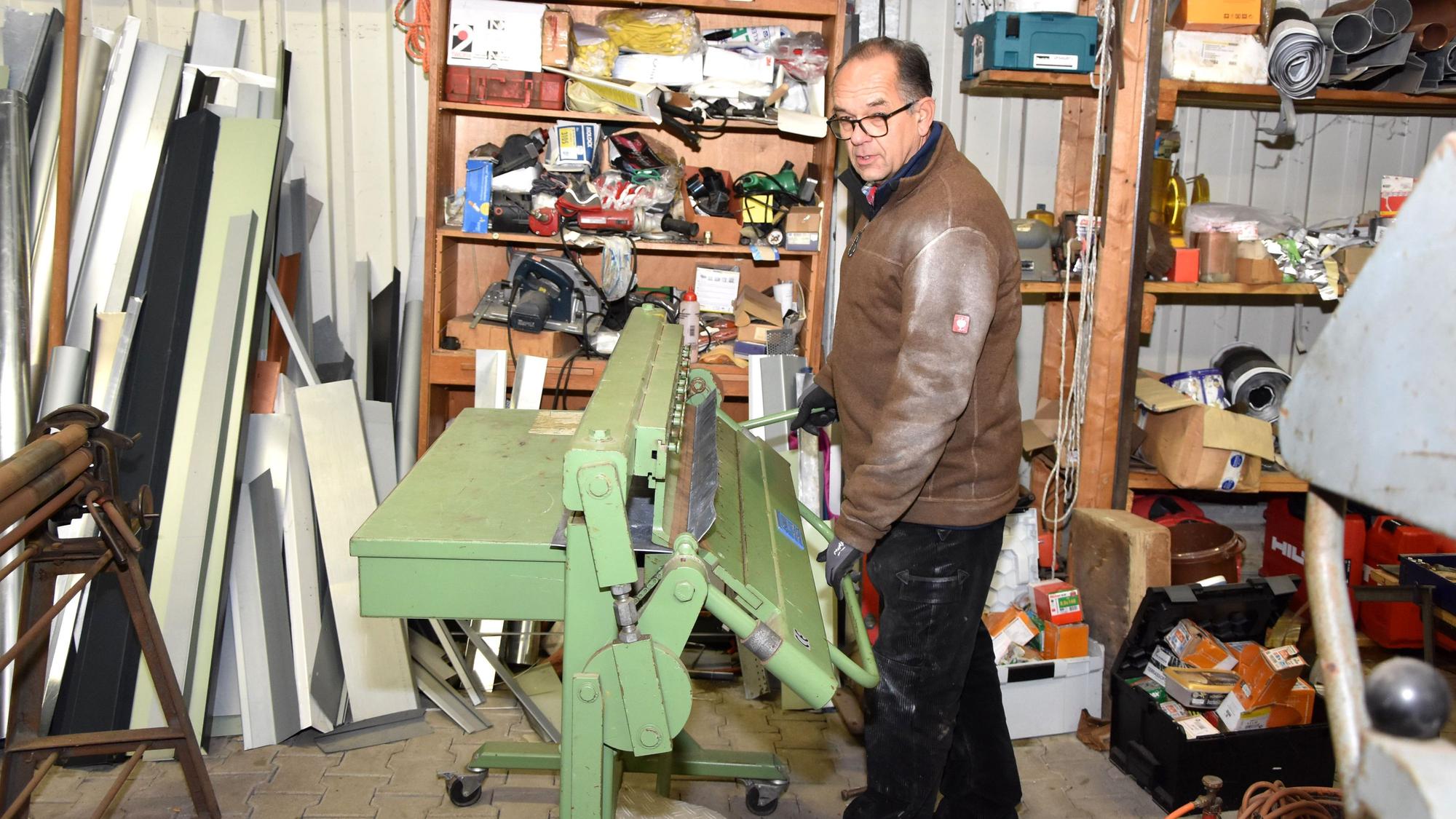Zu sehen ist Dachdecker Michael Nebeler in seiner Werkstatt.