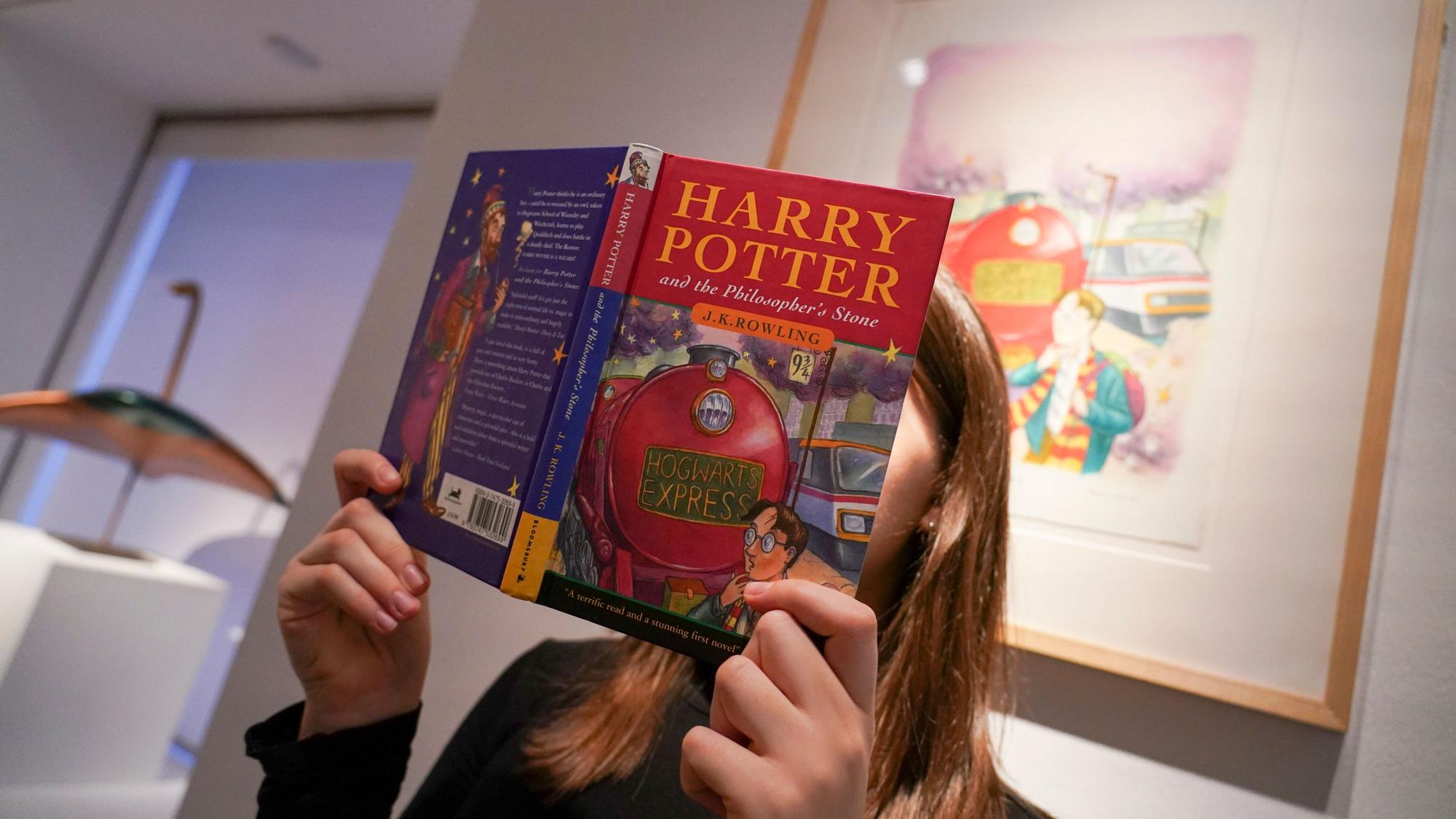 A member of staff holds a first edition of J.K. Rowling's "Harry Potter and the Philosopher's Stone", as it is set to go on auction at Christie's on the Classic Week, for an estimate of £800,000-120,000, in London, Friday, Nov. 29, 2024.(AP Photo/Alberto Pezzali)