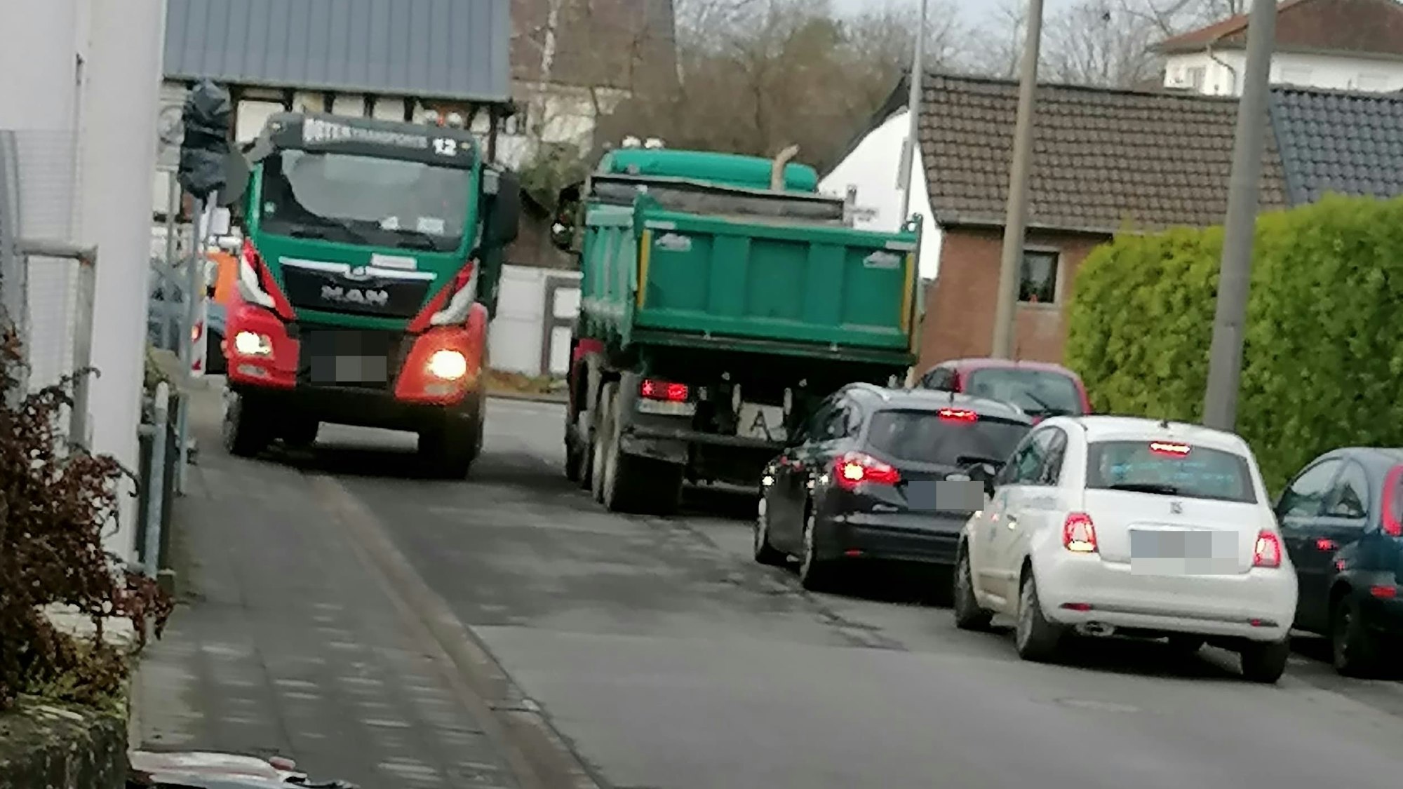 Zwei Lastwagen können in der engen Siegburger Straße nicht nebeneinander fahren.