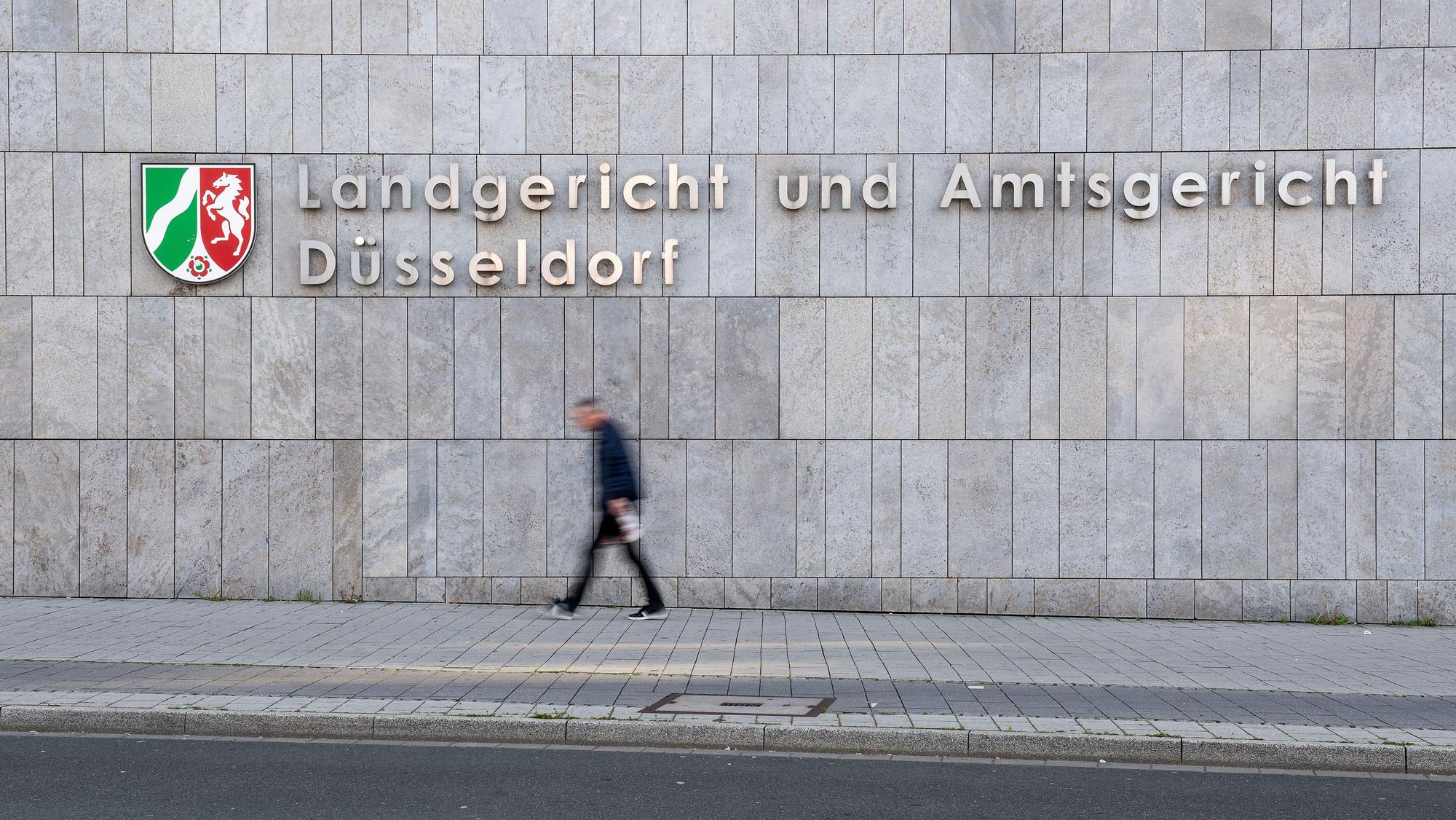 ARCHIV - 29.04.2019, Nordrhein-Westfalen, Düsseldorf: Ein Mann geht am Landgericht und Amtsgericht Düsseldorf vorbei.