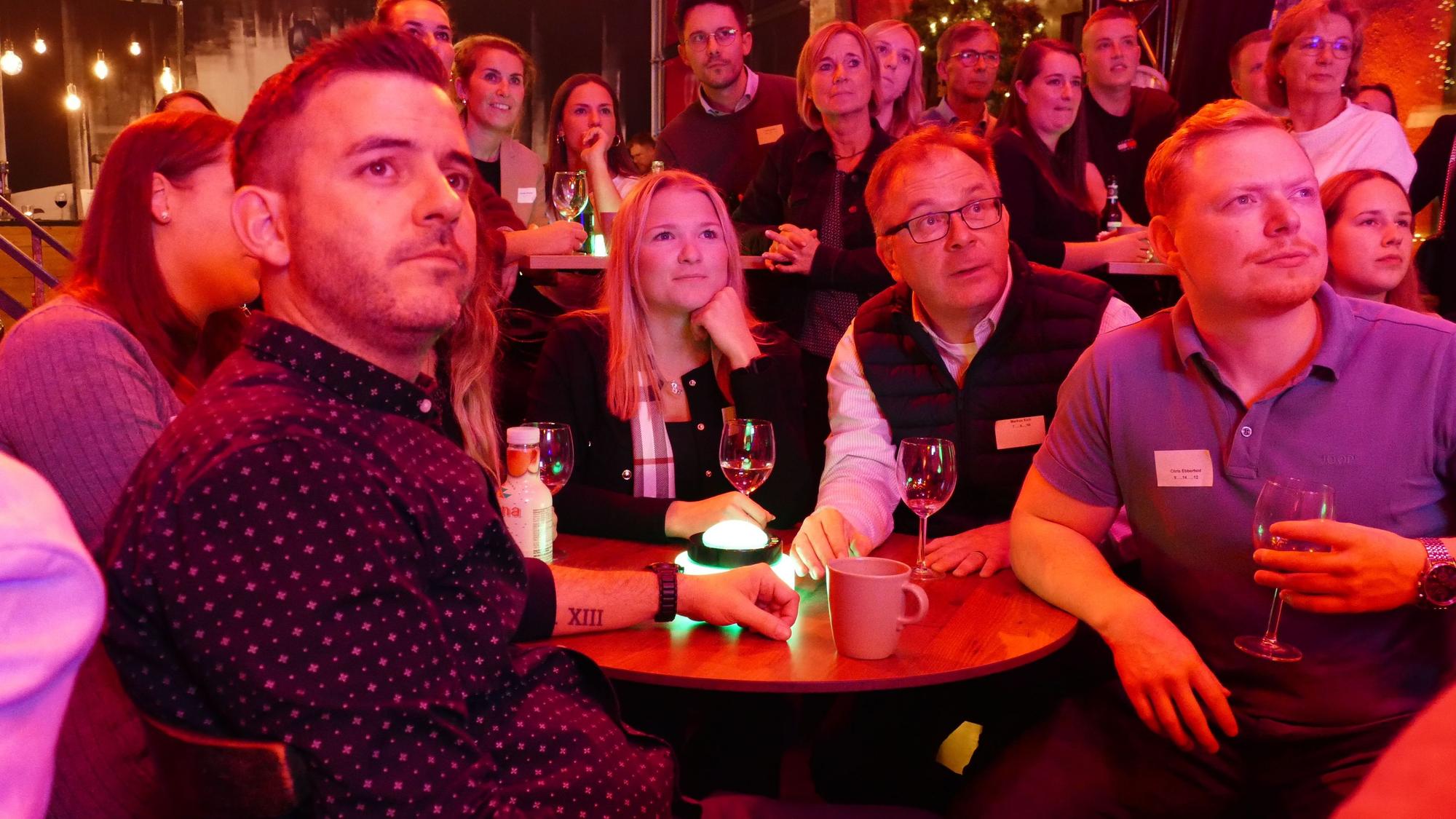 Gäste einer Quizshow an einem Tisch