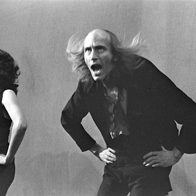 Schwarz-Weiß-Foto von der Premiere der „Rocky Horror Show“ im Royal Court Theatre Upstairs von Douglas H Jeffery: Patricia Quinn trägt als Magenta ein offenes Kleid und einen schwarzen BH, Richard O'Brien als Riff Raff ein schwarzes Jackett.