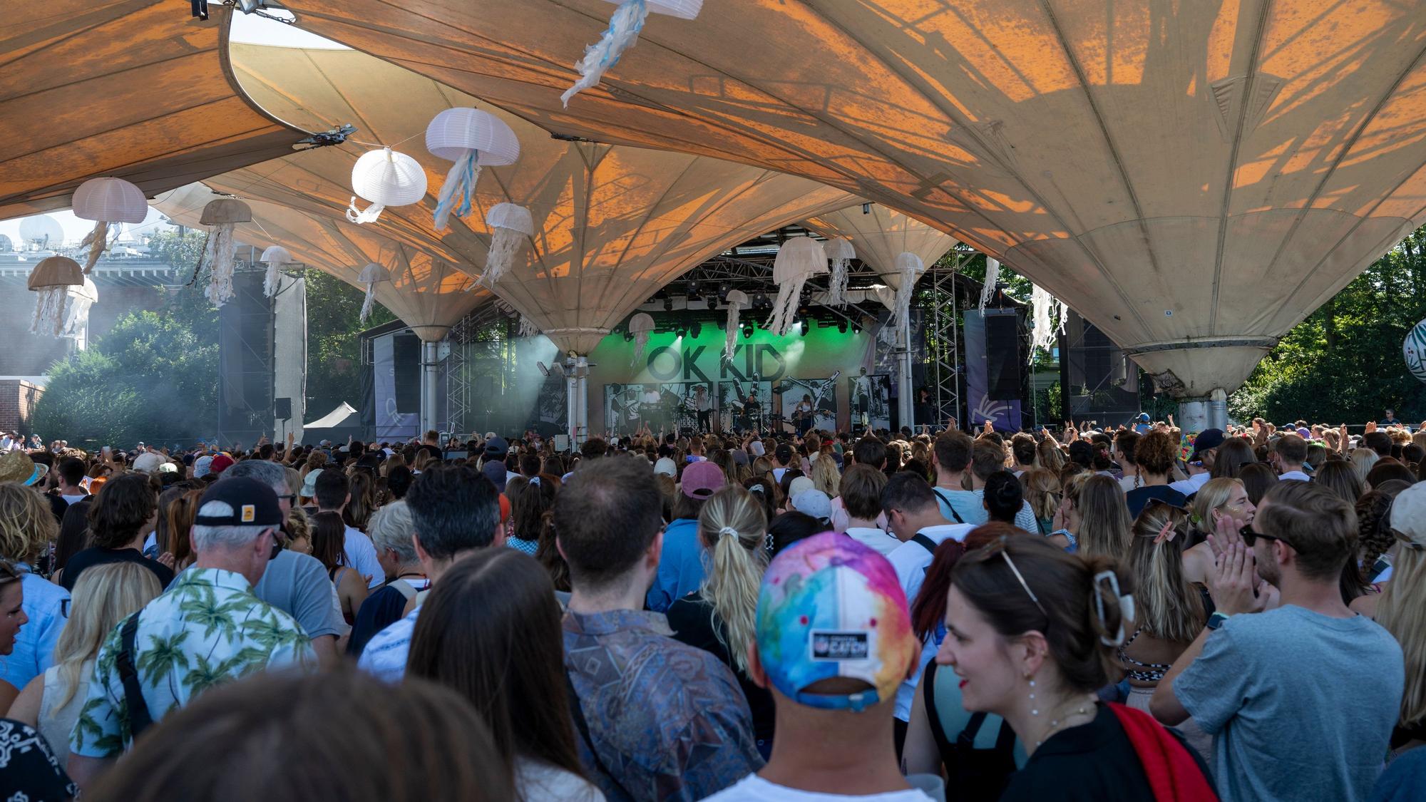 Menschen stehen im Tanzbrunnen vor einer Bühne.