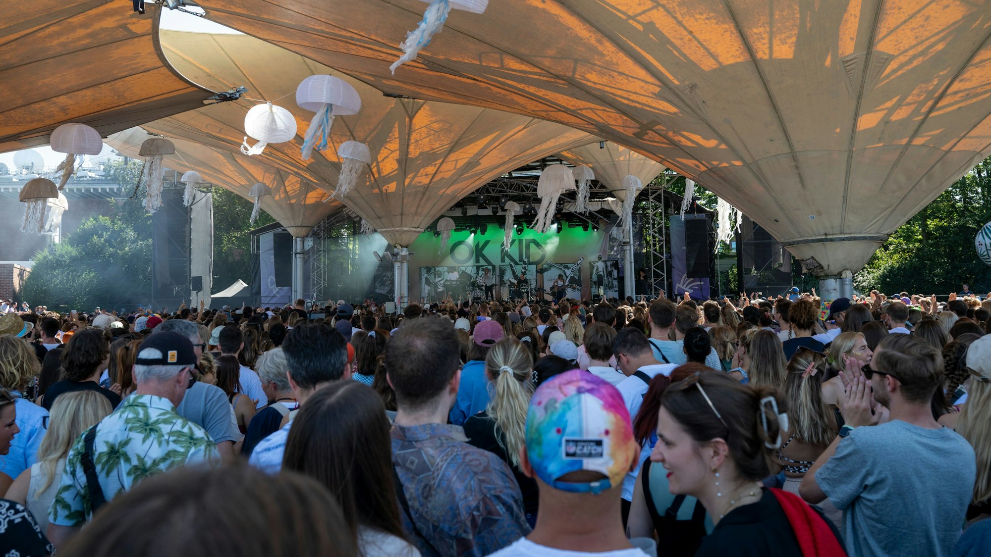 Menschen stehen im Tanzbrunnen vor einer Bühne.