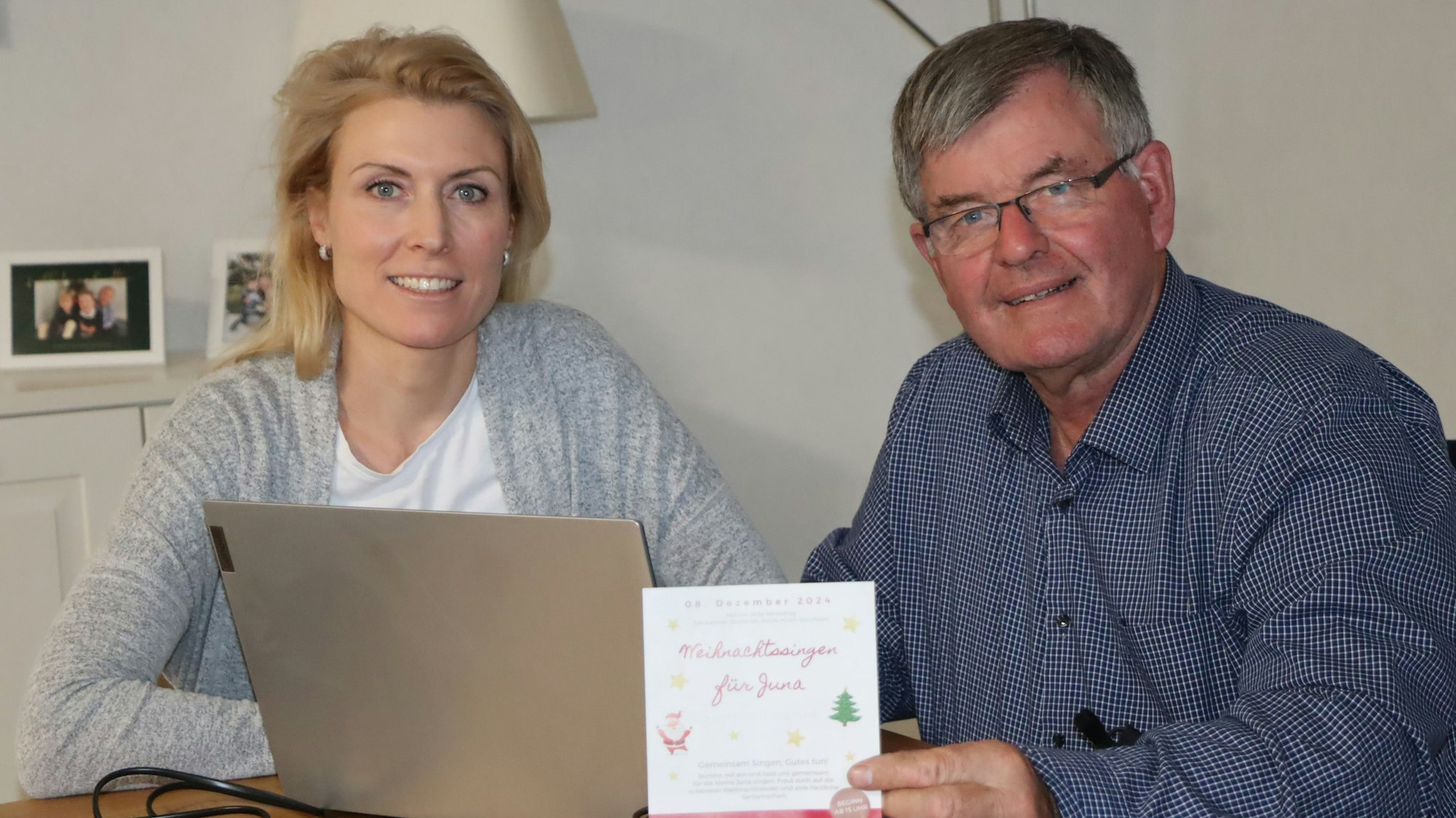Das Foto zeigt die beiden Organisatoren des Weihnachtssingens vor einem Laptop am Tisch.