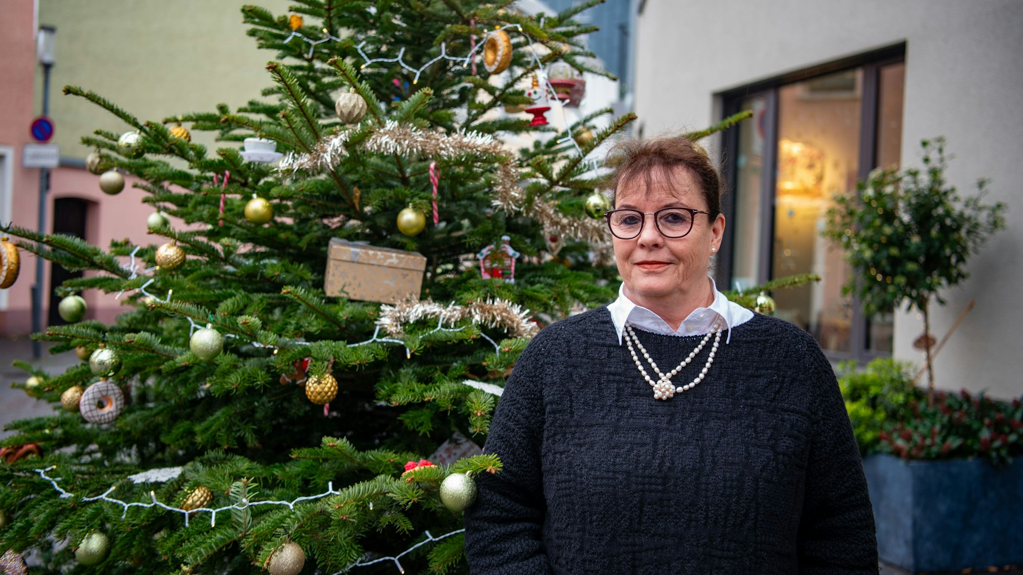Juliane B. Vetter steht vor einem geschmückten Weihnachtsbaum in der Zülpicher Innenstadt.