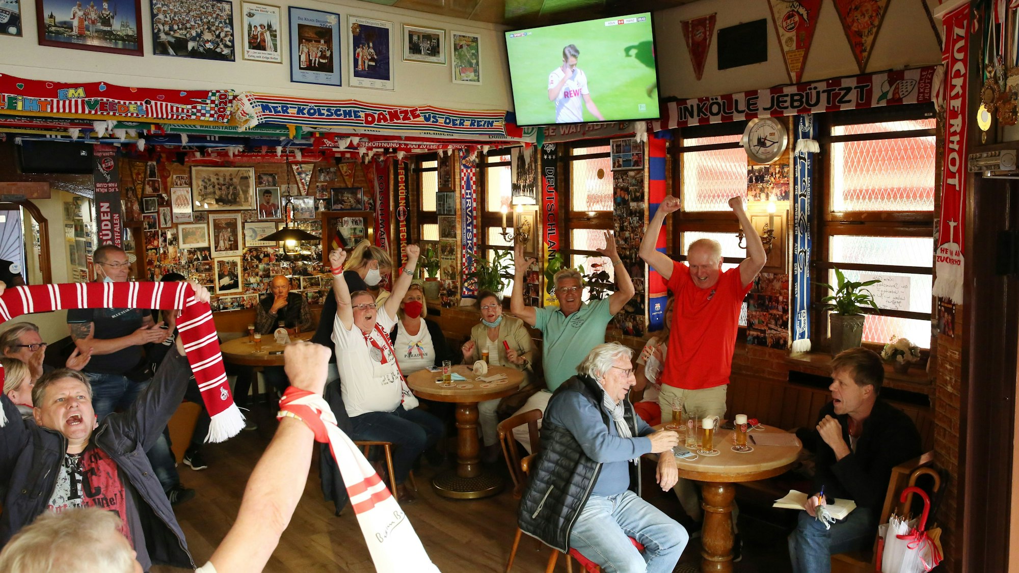 Fußballfans in der Kneipe jubeln.