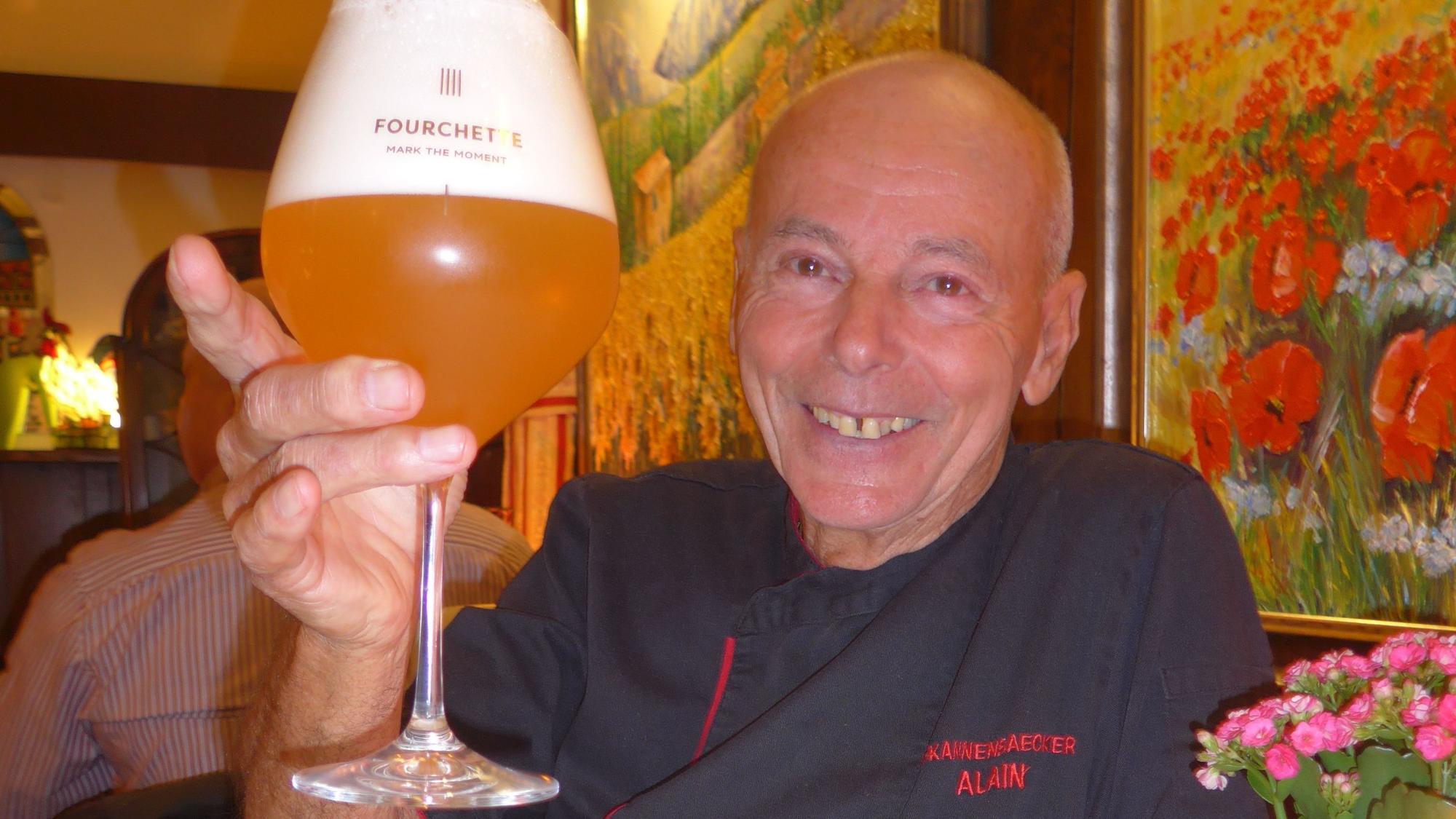 Auf dem Bild ist ein Gastronom mit einem Glas Bier zu sehen.