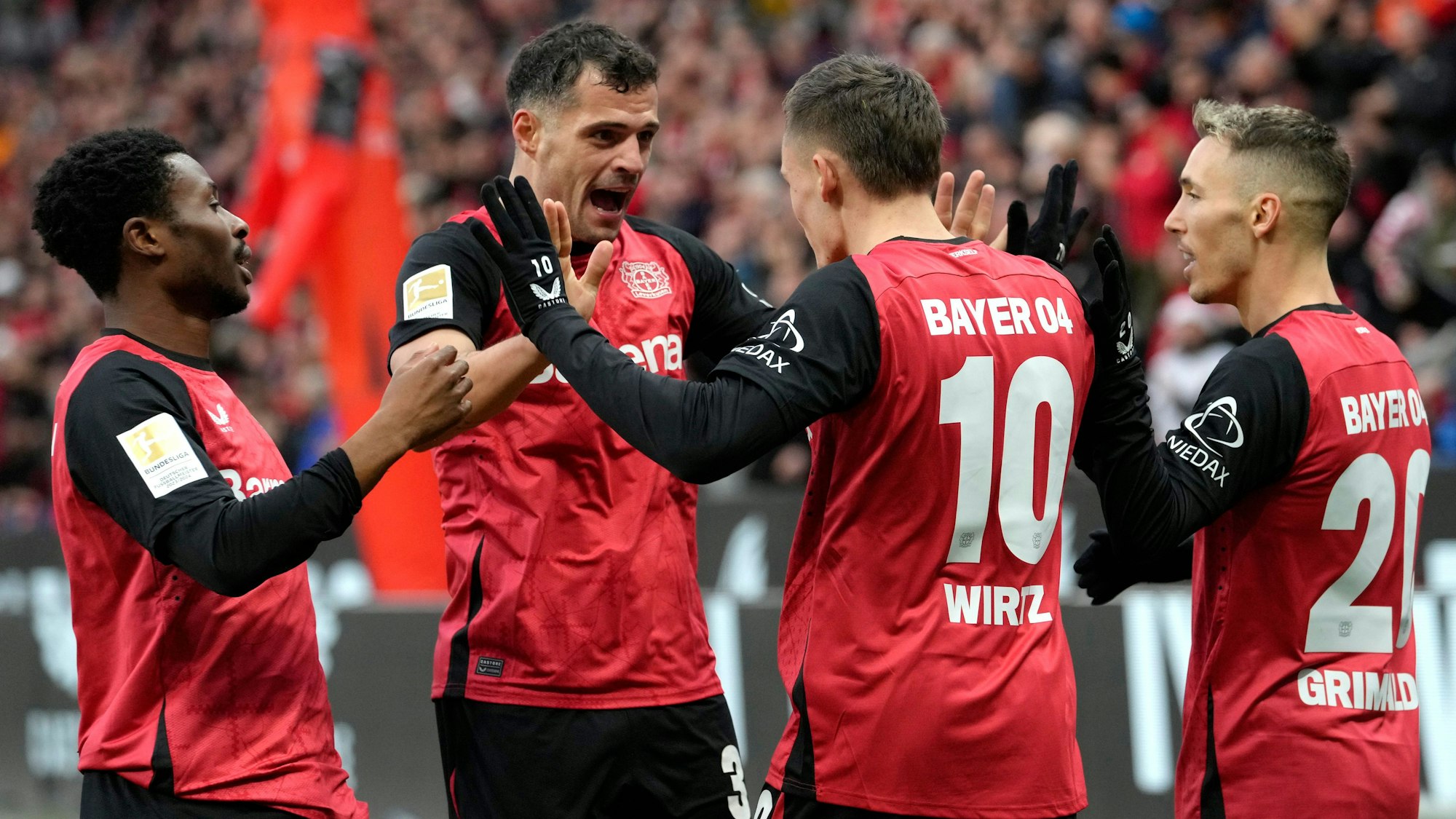 Leverkusen's Florian Wirtz, center right, celebrates with his teammates after scoring the first goal during the German Bundesliga soccer match between Bayer Leverkusen and St. Pauli at the BayArena in Leverkusen, Germany, Saturday, Dec. 7, 2024. (AP Photo/Martin Meissner)