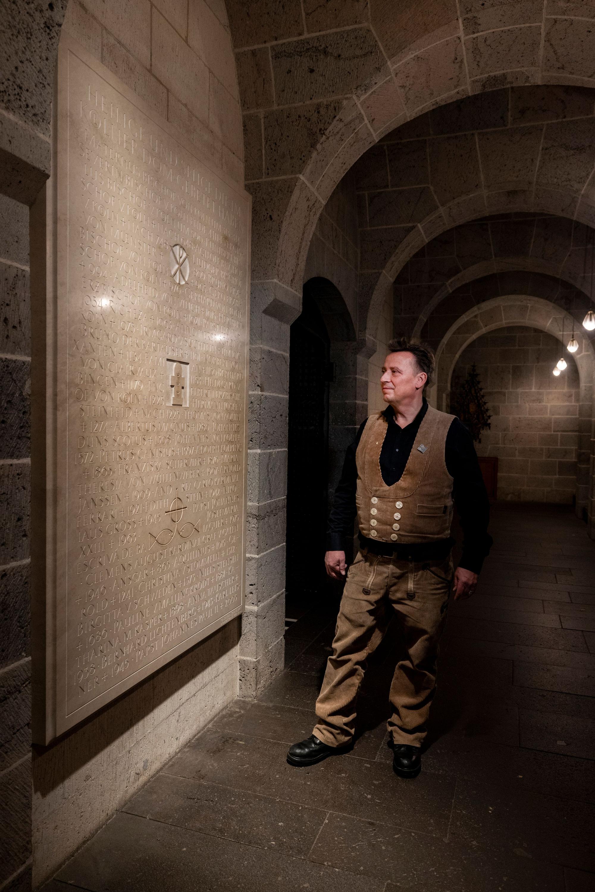Markus Heindl neben einer von ihm angefertigten Gedenktafel in der Krypta des Kölner Doms