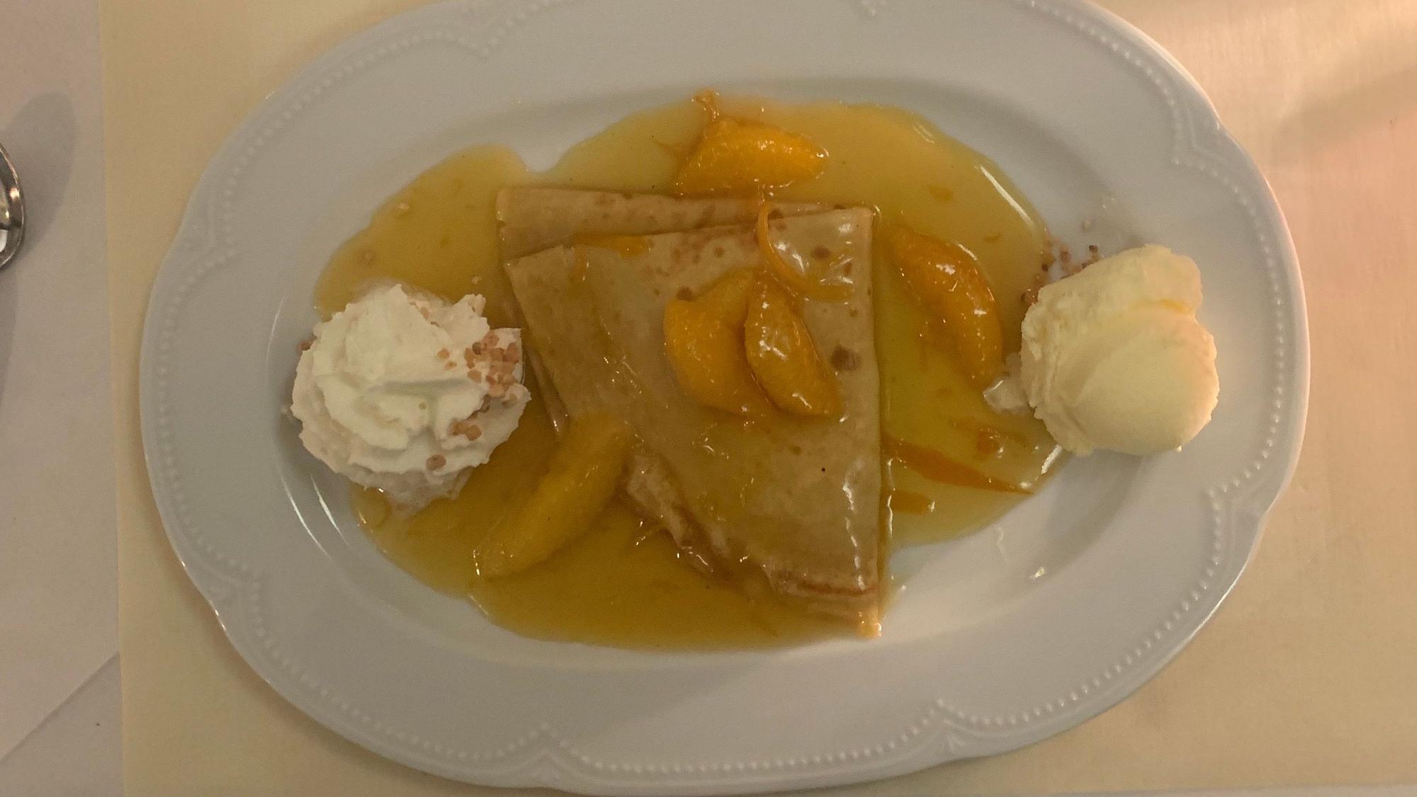 Auf dem Bild ist ein weißer Teller mit einem Dessert zu sehen.
