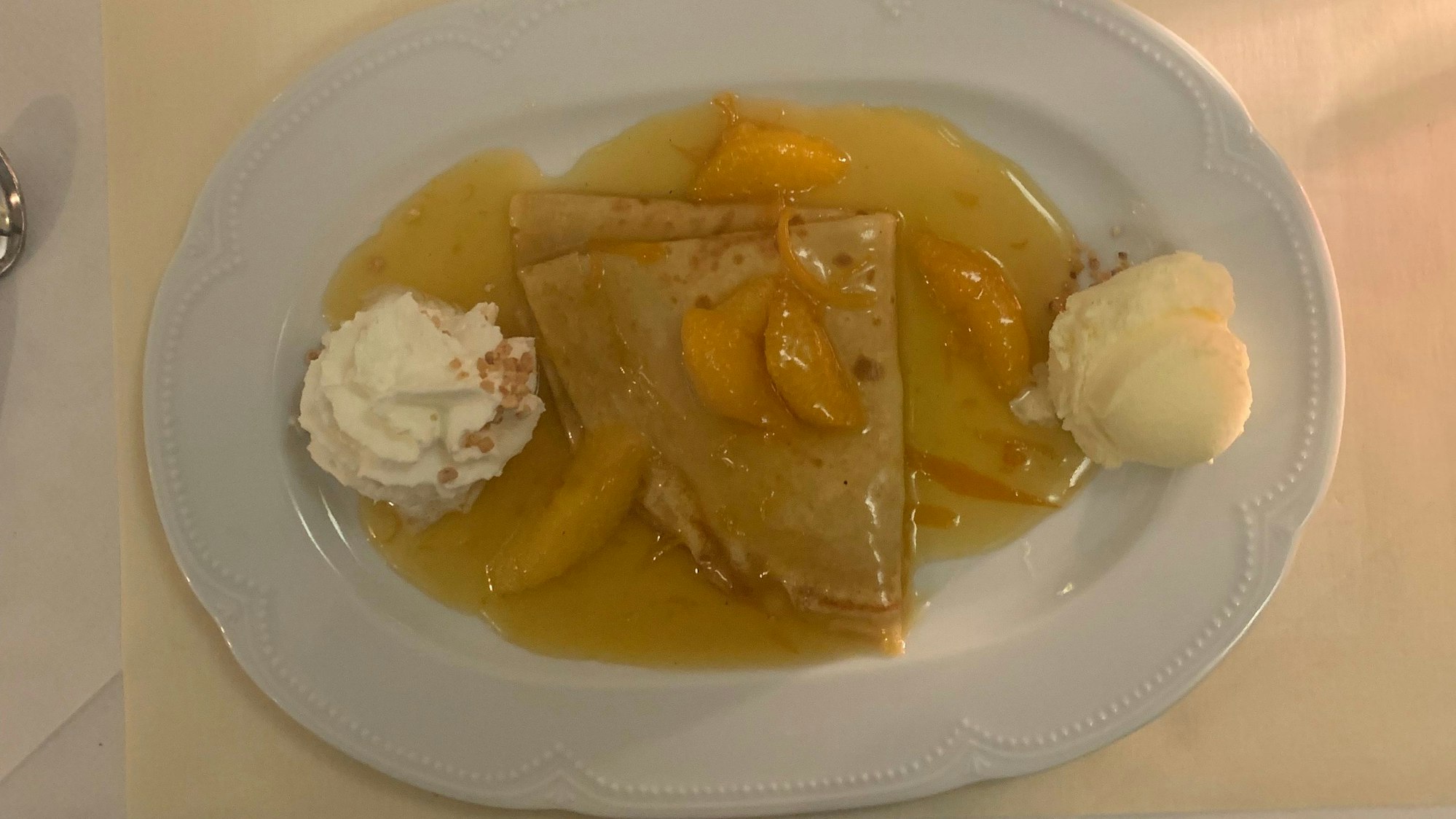 Auf dem Bild ist ein weißer Teller mit einem Dessert zu sehen.