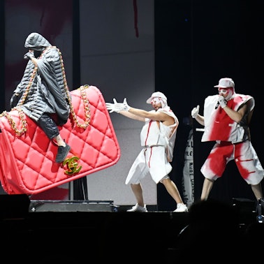 Kryptik Joe, das einzig verbliebene Original-Mitglied von Deichkind, reitet bei ihrer Show in Köln eine rote Chanel-Tasche.