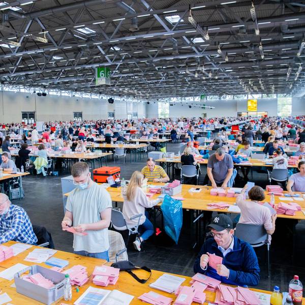 Wahlhelferinnen und Wahlhelfer öffnen bei der Auszählung der Briefwahl zur Bundestagswahl in der Messehalle 6 die rosafarbenen Umschläge. +++ dpa-Bildfunk +++