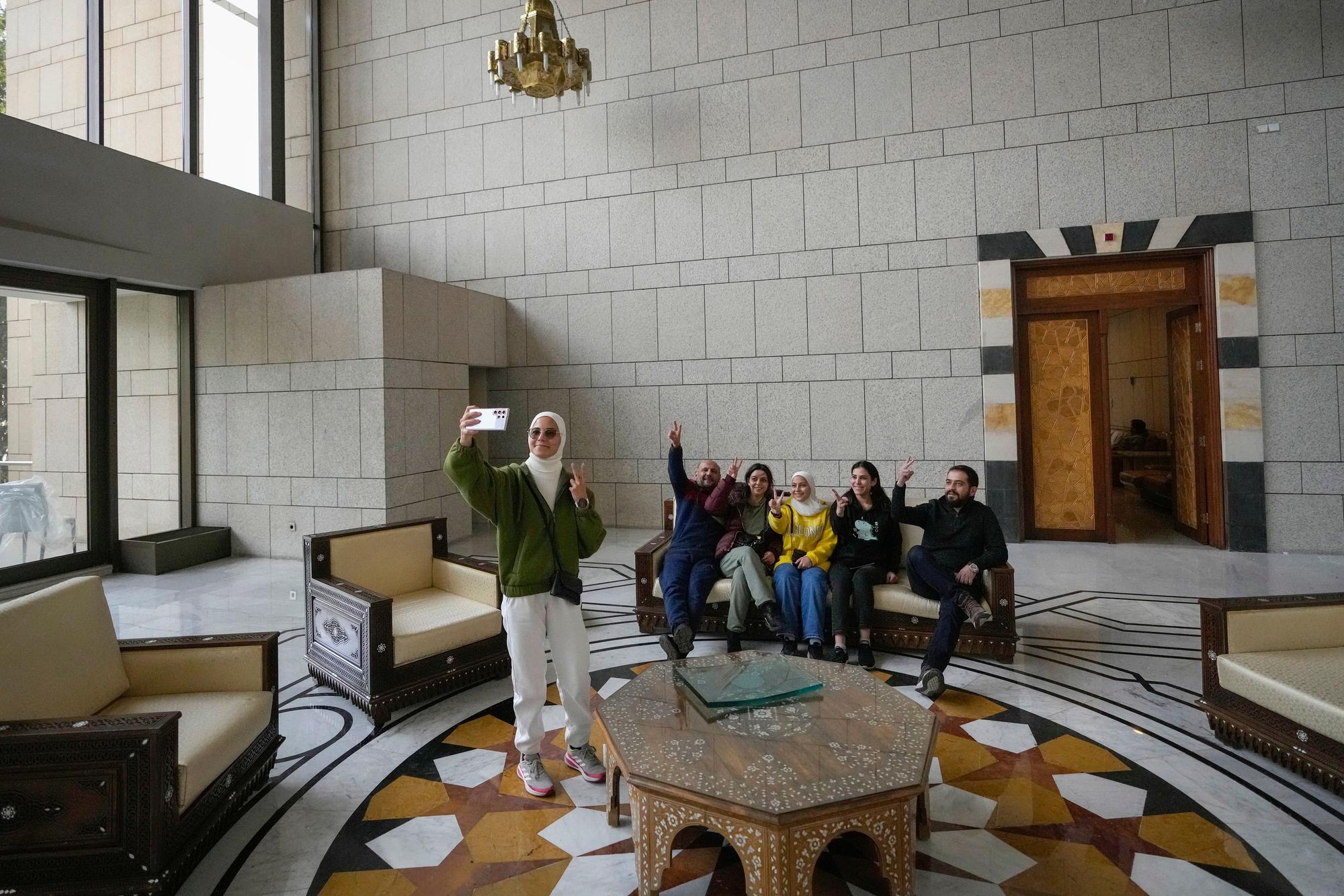 Eine Gruppe von Menschen macht ein Familienfoto im Präsidentenpalast in Damaskus, nach dem der syrische Machthaber al-Assad von Rebellen gestürzt worden war.
