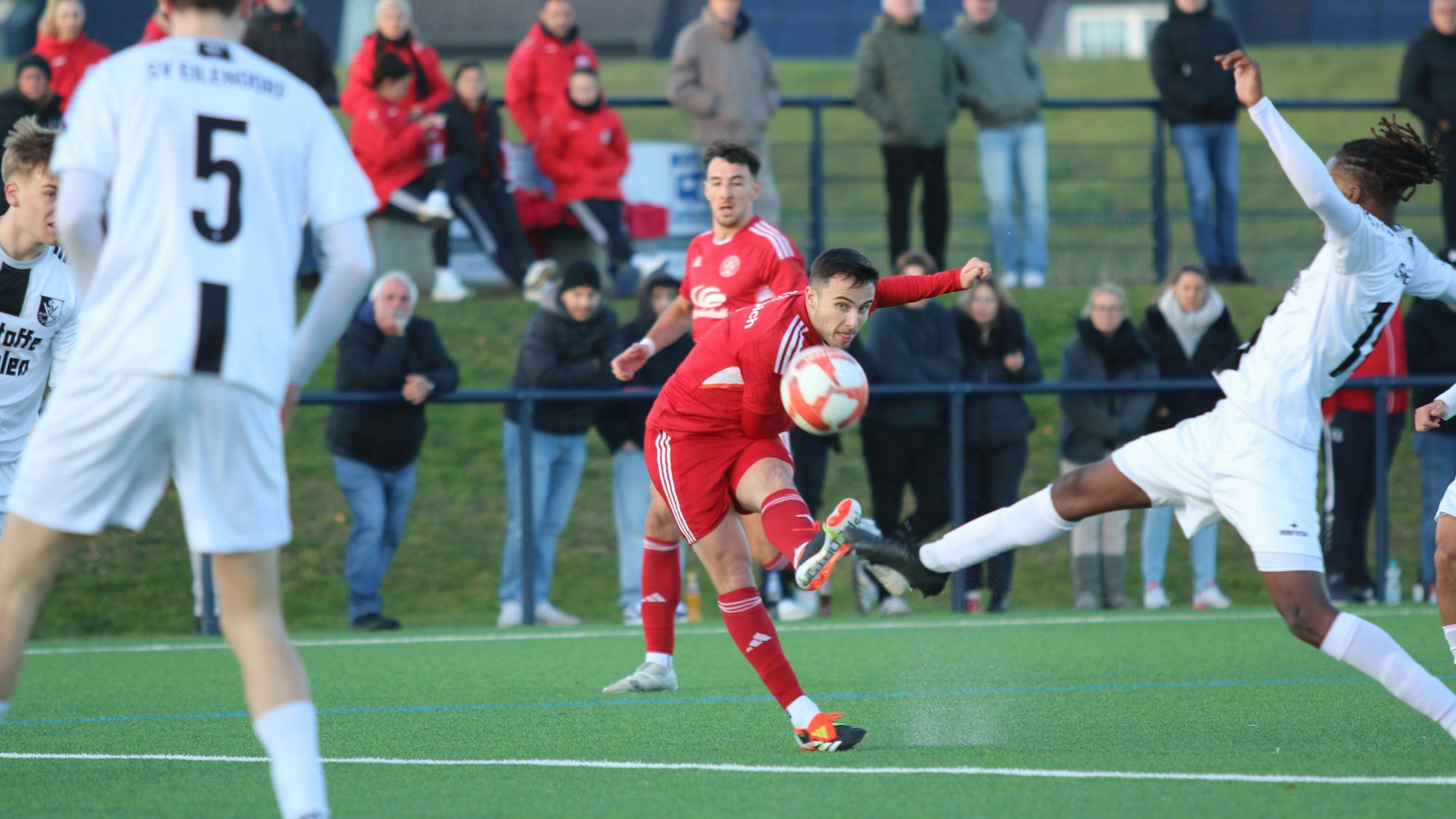 Zülpichs Marlon Große schießt aus der Distanz. Ein Verteidiger versucht, ein Bein vor den Ball zu bekommen.