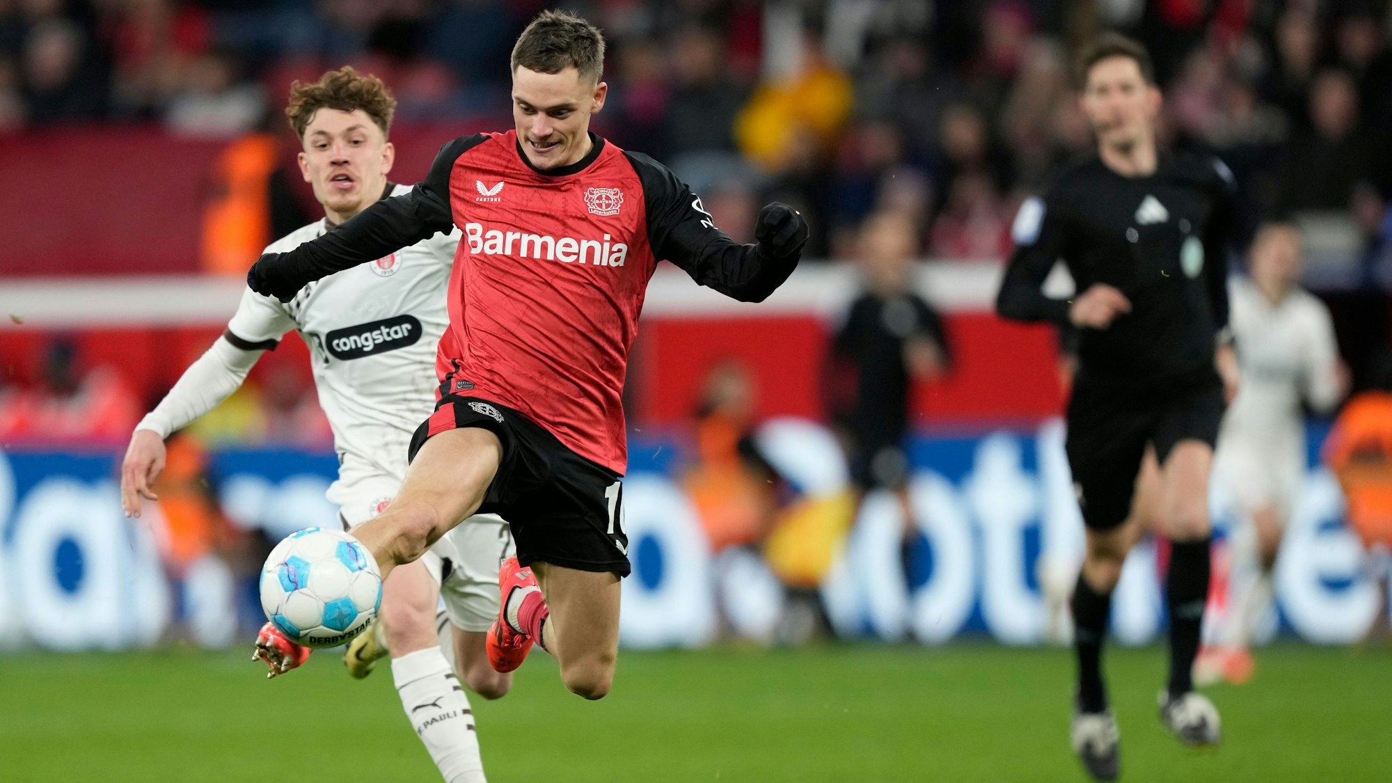 Leverkusen's Florian Wirtz, right, controls the ball by St. Pauli's Philipp Treu during the German Bundesliga soccer match between Bayer Leverkusen and St. Pauli at the BayArena in Leverkusen, Germany, Saturday, Dec. 7, 2024. (AP Photo/Martin Meissner)