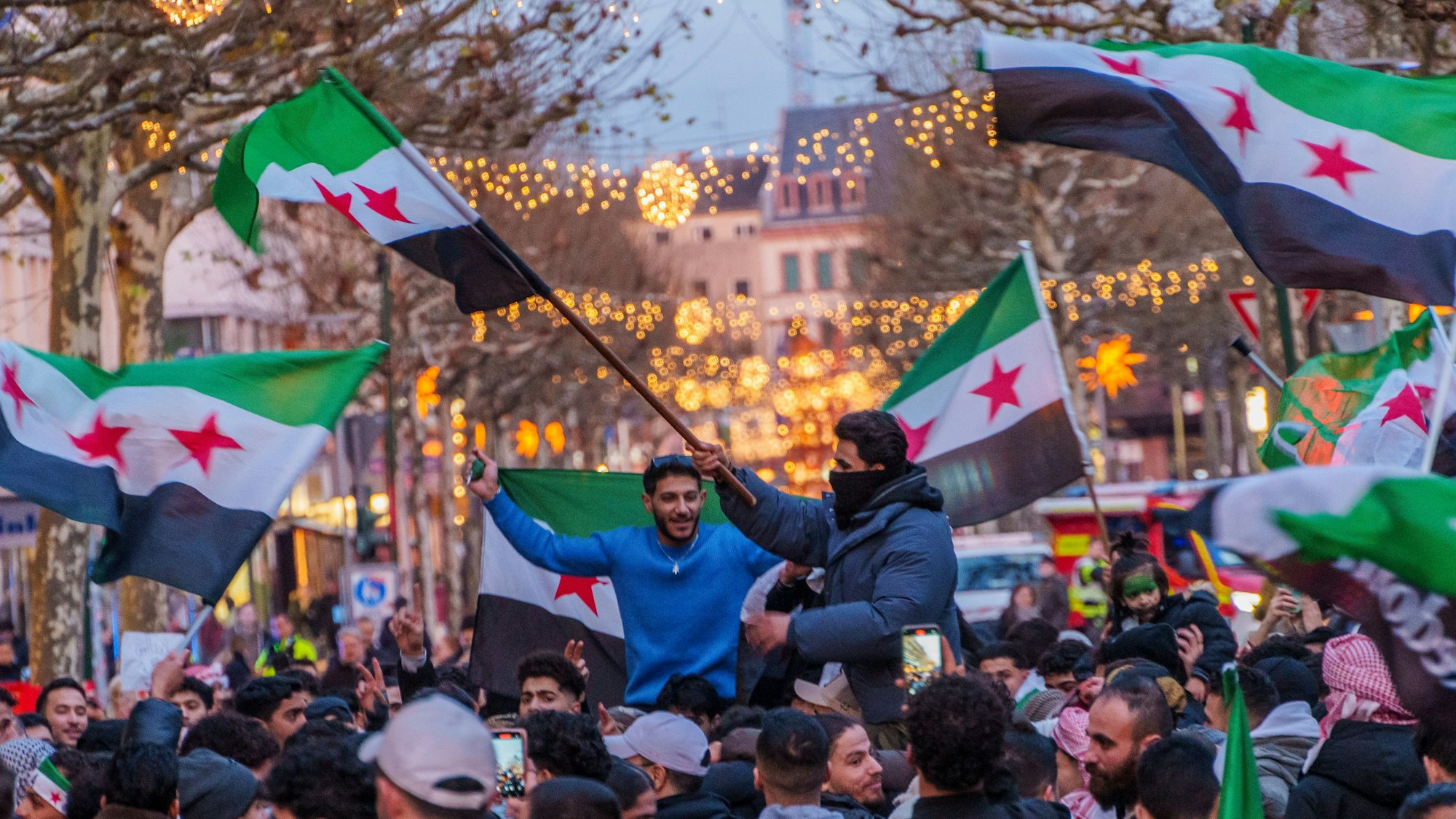 Syrer feiern auf dem Schillerplatz in Mainz den Sturz des Assad-Regime.