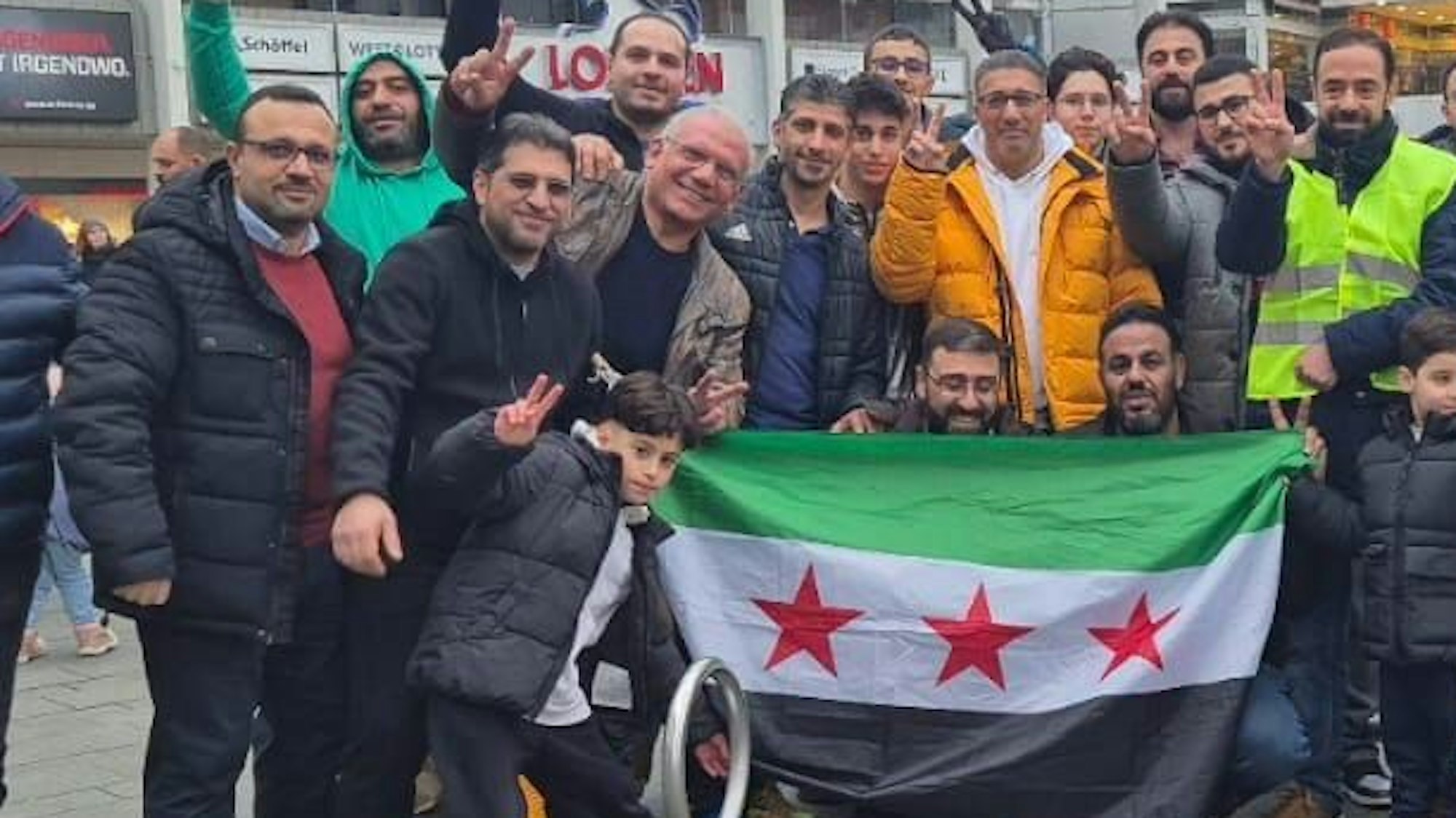 Syrer feiern in der Bergisch Gladbacher Innenstadt. Qutaibah Alkassat (rechts in der gelben Weste) feiert mit.