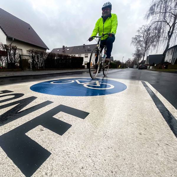 Ein Fahrradfahrer fährt über Fahrrad-Zone-Markierung.