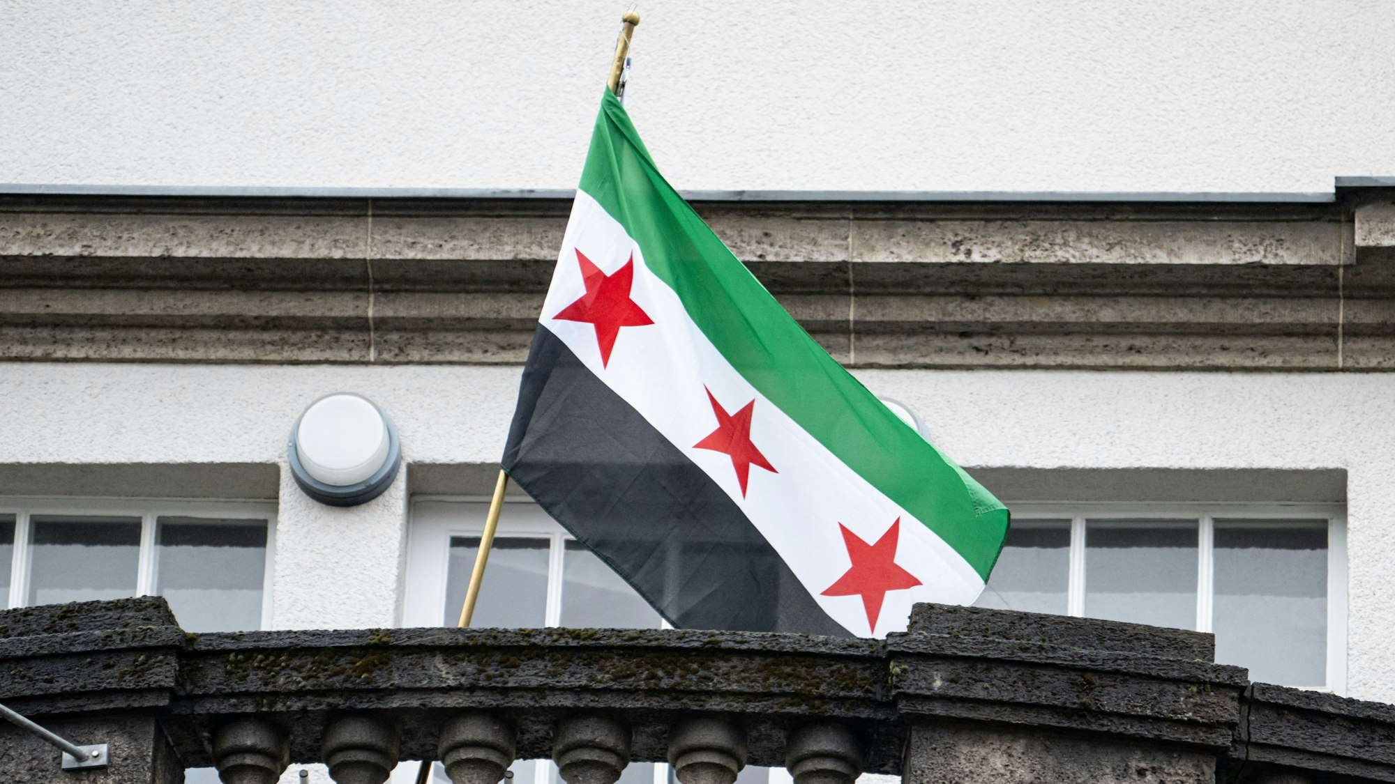 09.12.2024, Berlin: Die Flagge der syrischen Revolution weht auf dem Balkon der syrischen Botschaft.