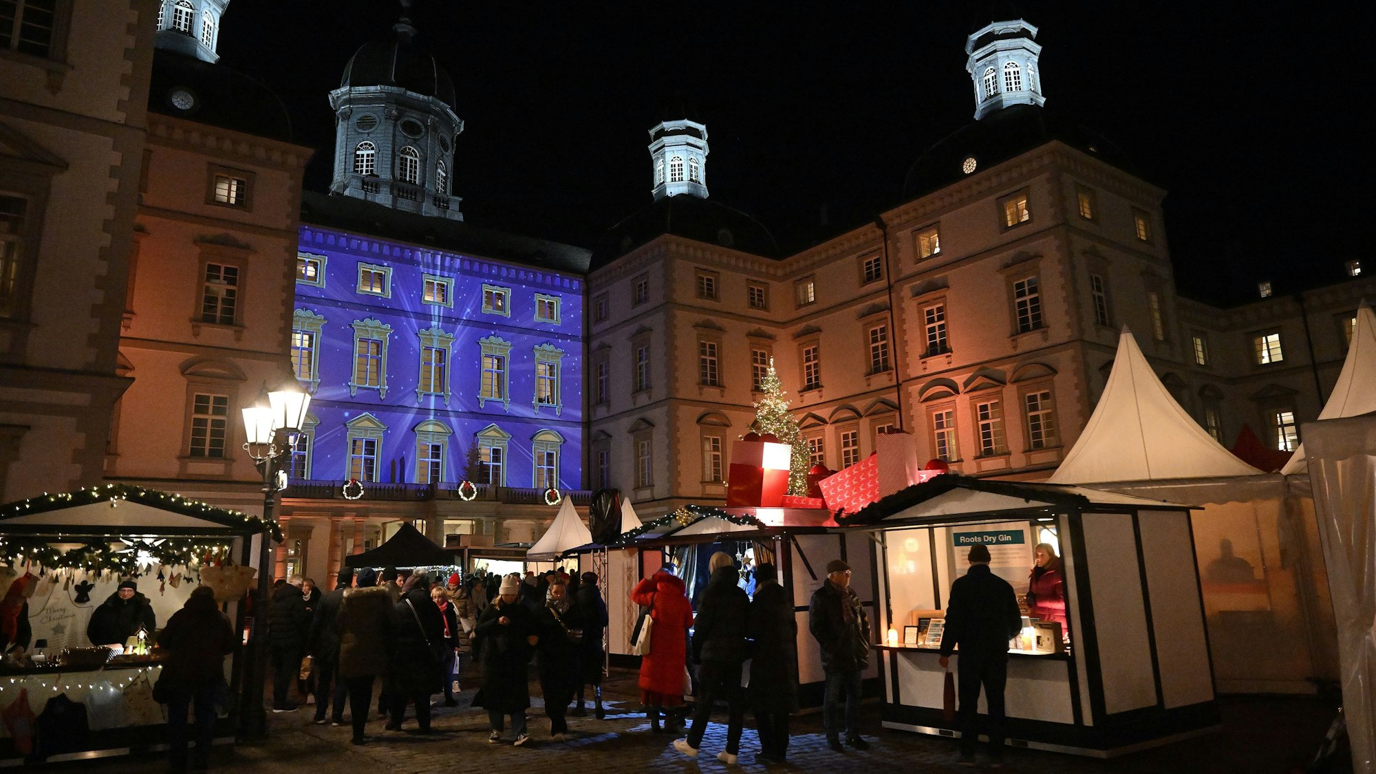 Blick über den Weihnachtsmarkt aufs Bensberger Schloss am Abend.