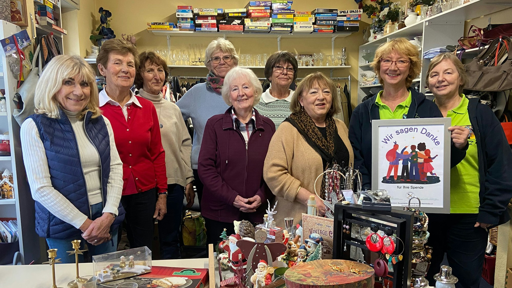 Neun Damen stehen nebeneinander in einem Raum. Eine hält ein Plakat mit der Aufschrift Wir sagen Danke.