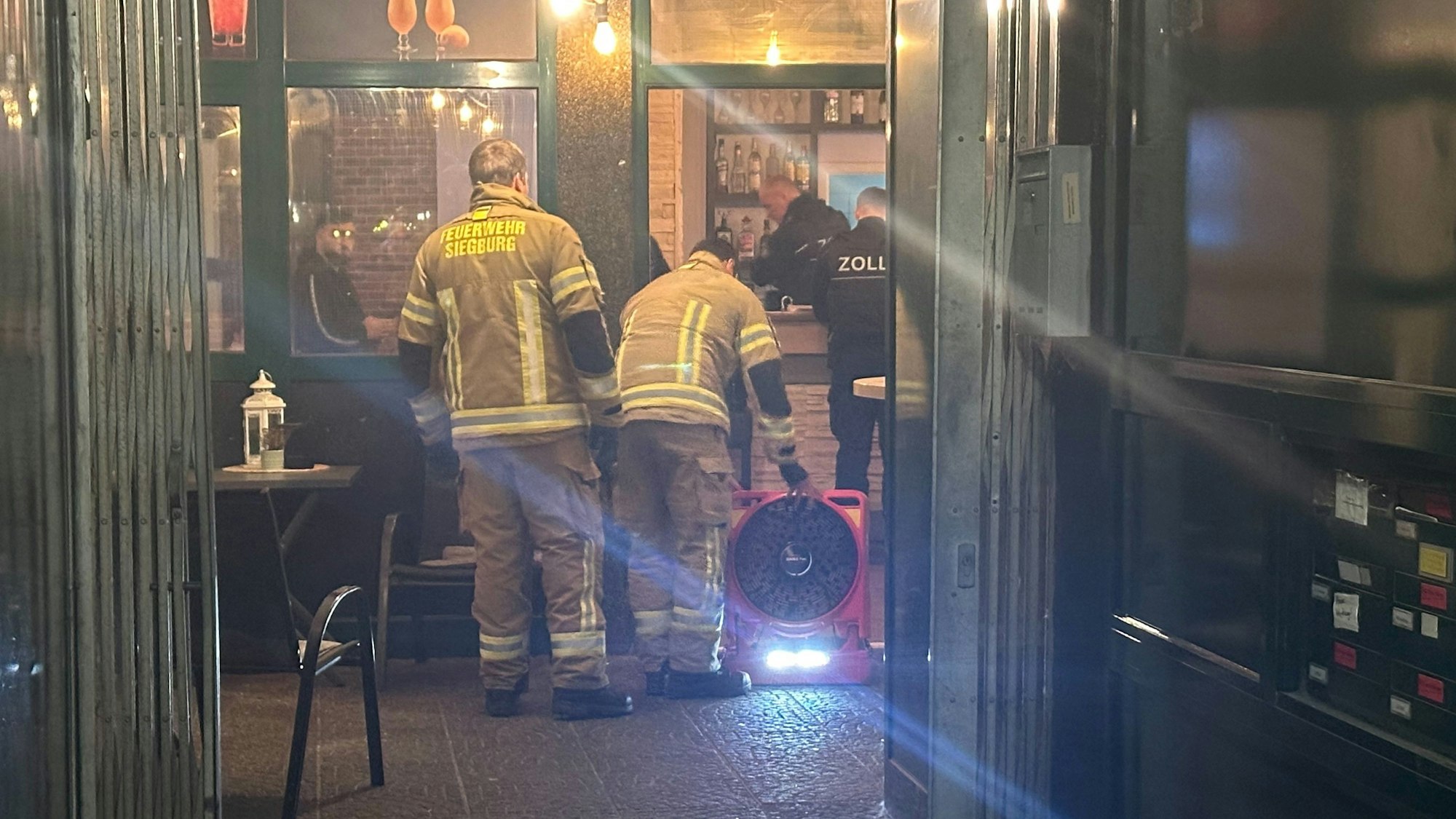 Feuerwehrleute lüften die Räume einer Bar.