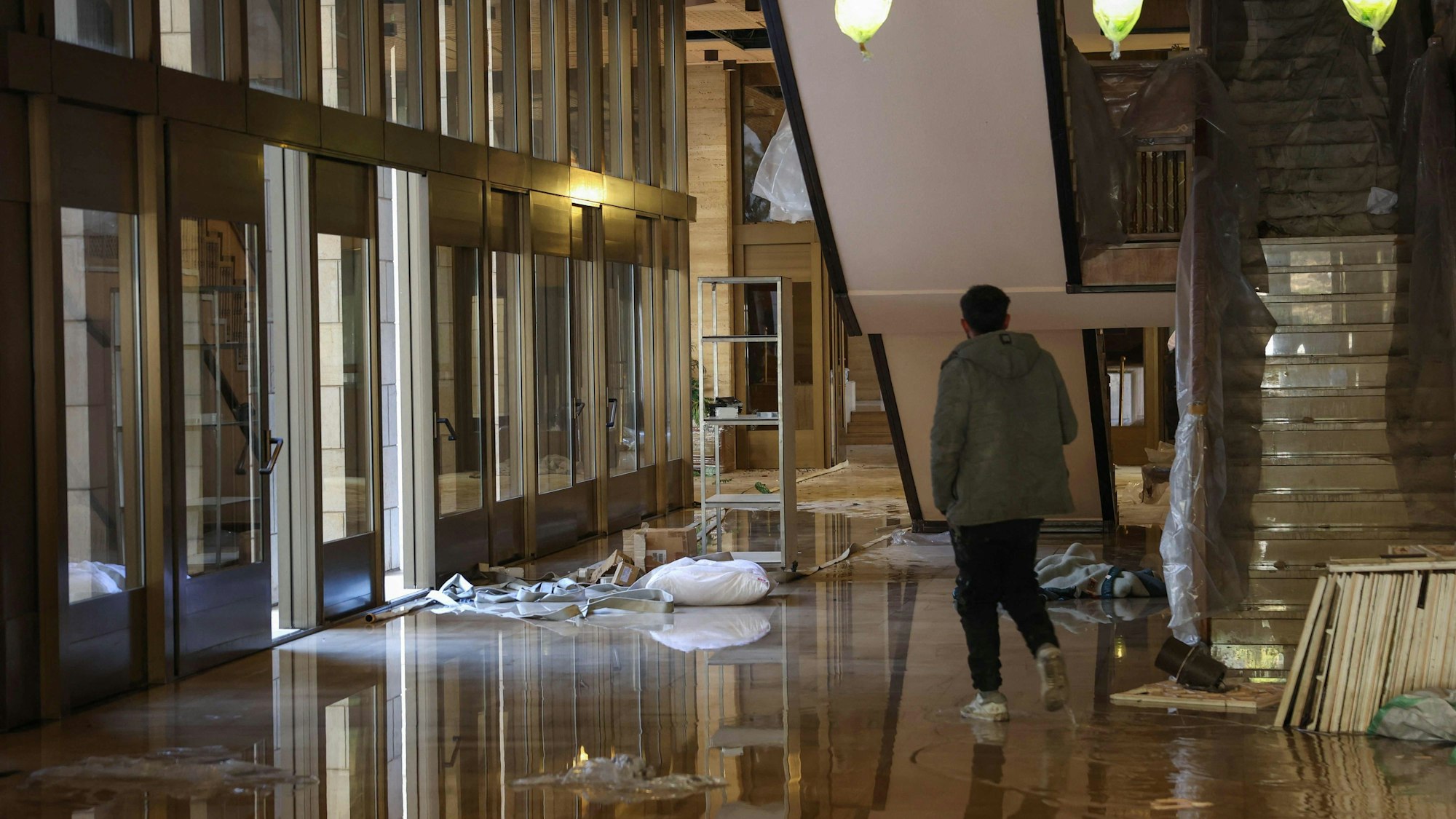 Ein Mann läuft durch eine verwüstete Halle im Assad-Palast.