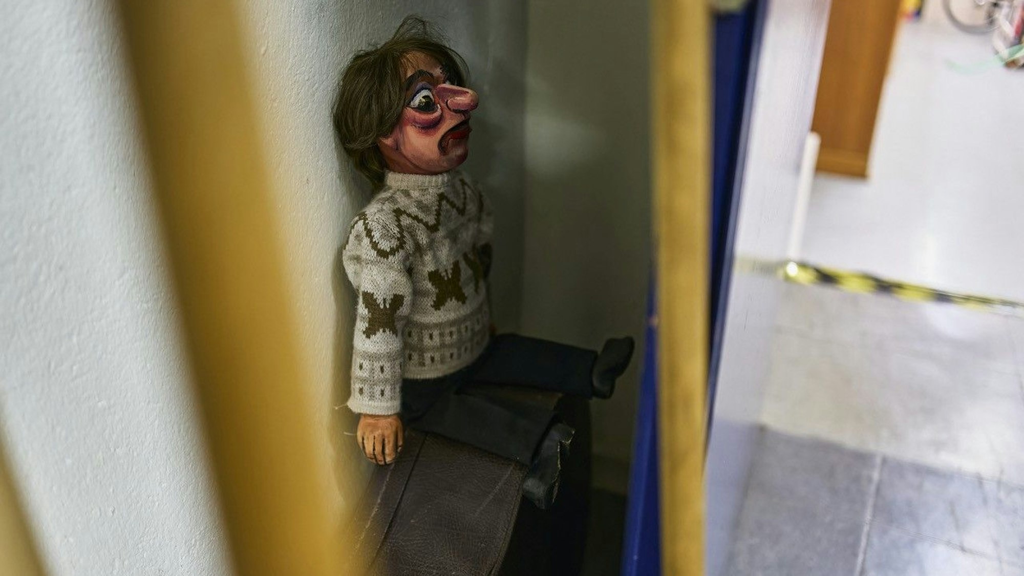 Eine Puppenfigur sitzt in der Ecke.