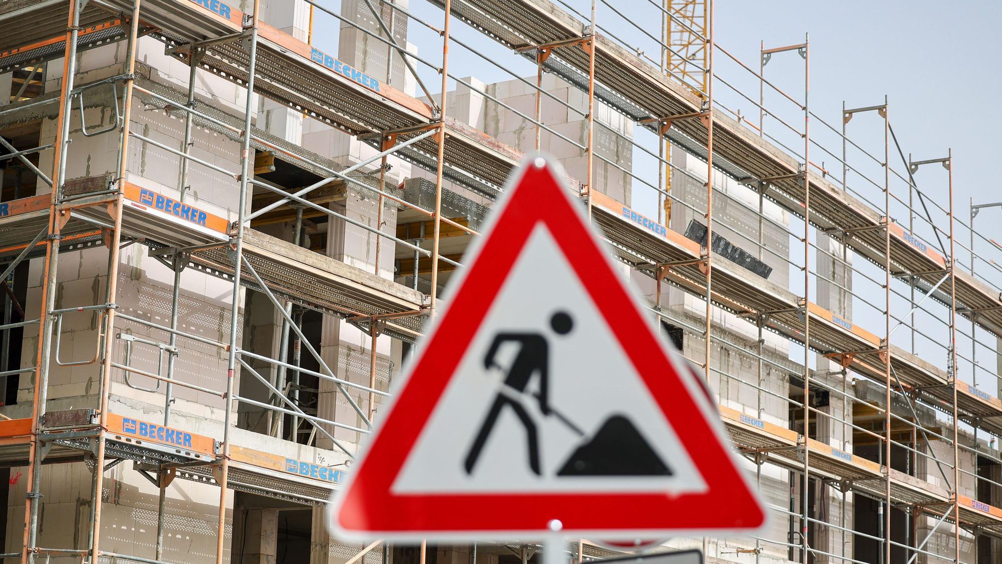 Ein Schild warnt vor einer Baustelle für Wohnhäuser.
