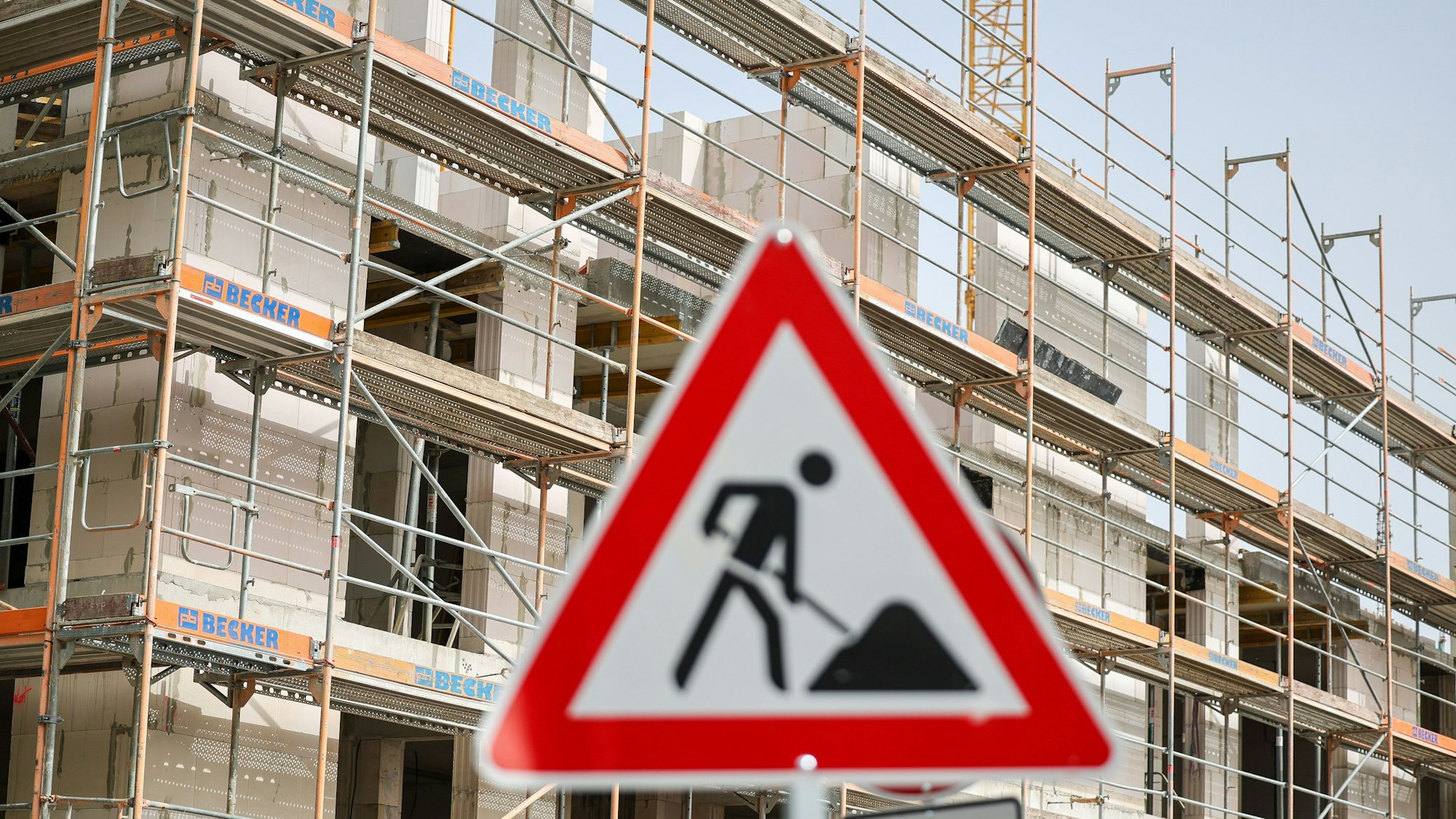 Ein Schild warnt vor einer Baustelle für Wohnhäuser.