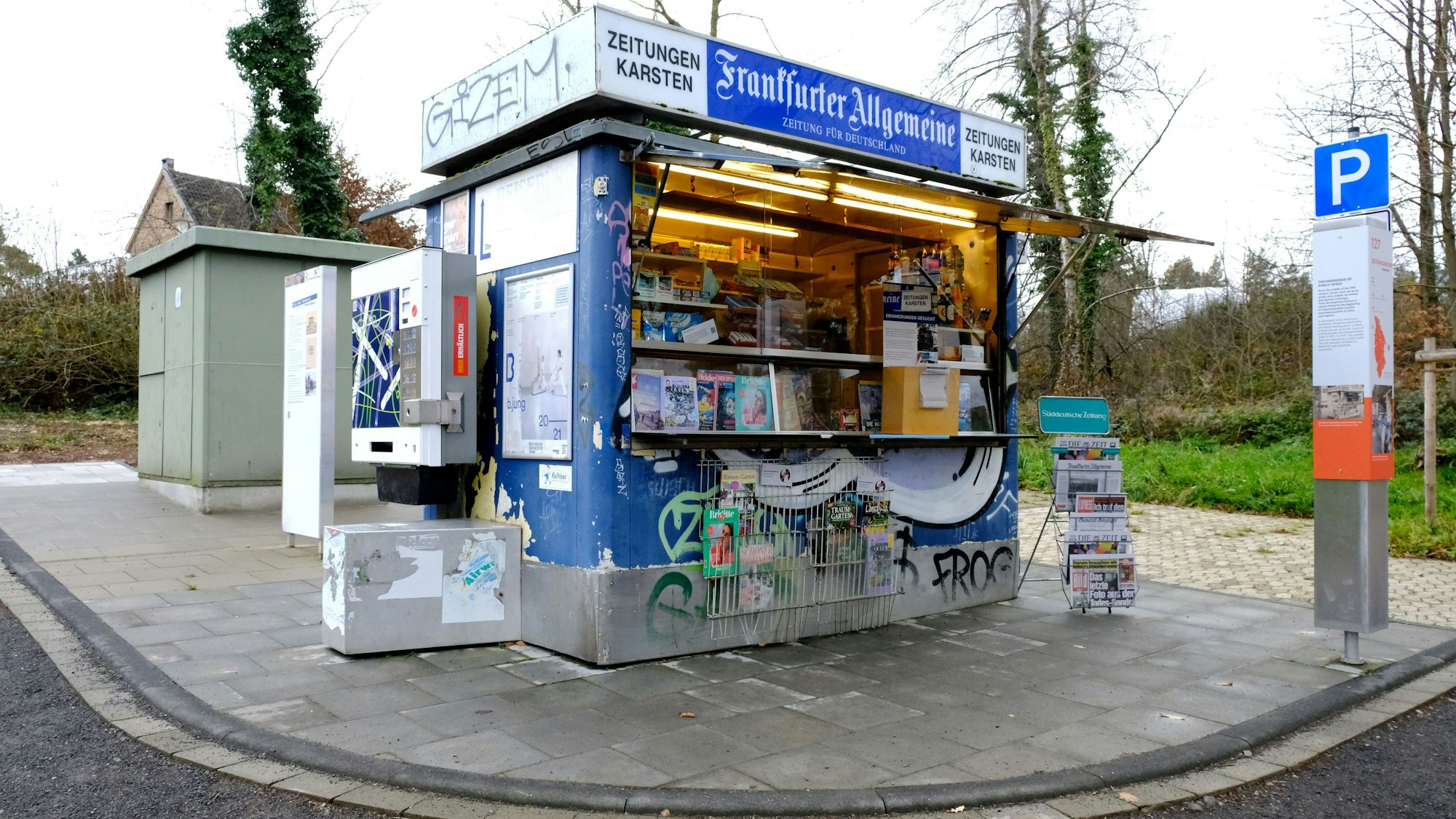 Ein Zeitungsbüdchen steht an einem Wegesrand.