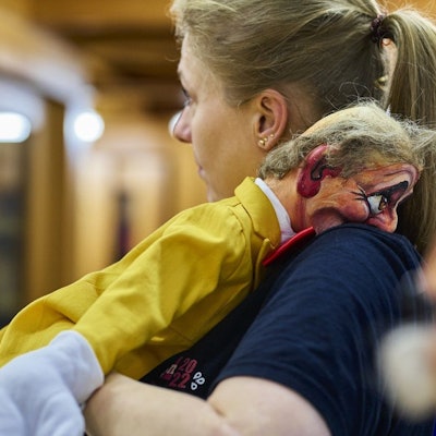 Auf der Schulter von Puppenspielerin Almuth Solzbacher liegt eine Puppe.