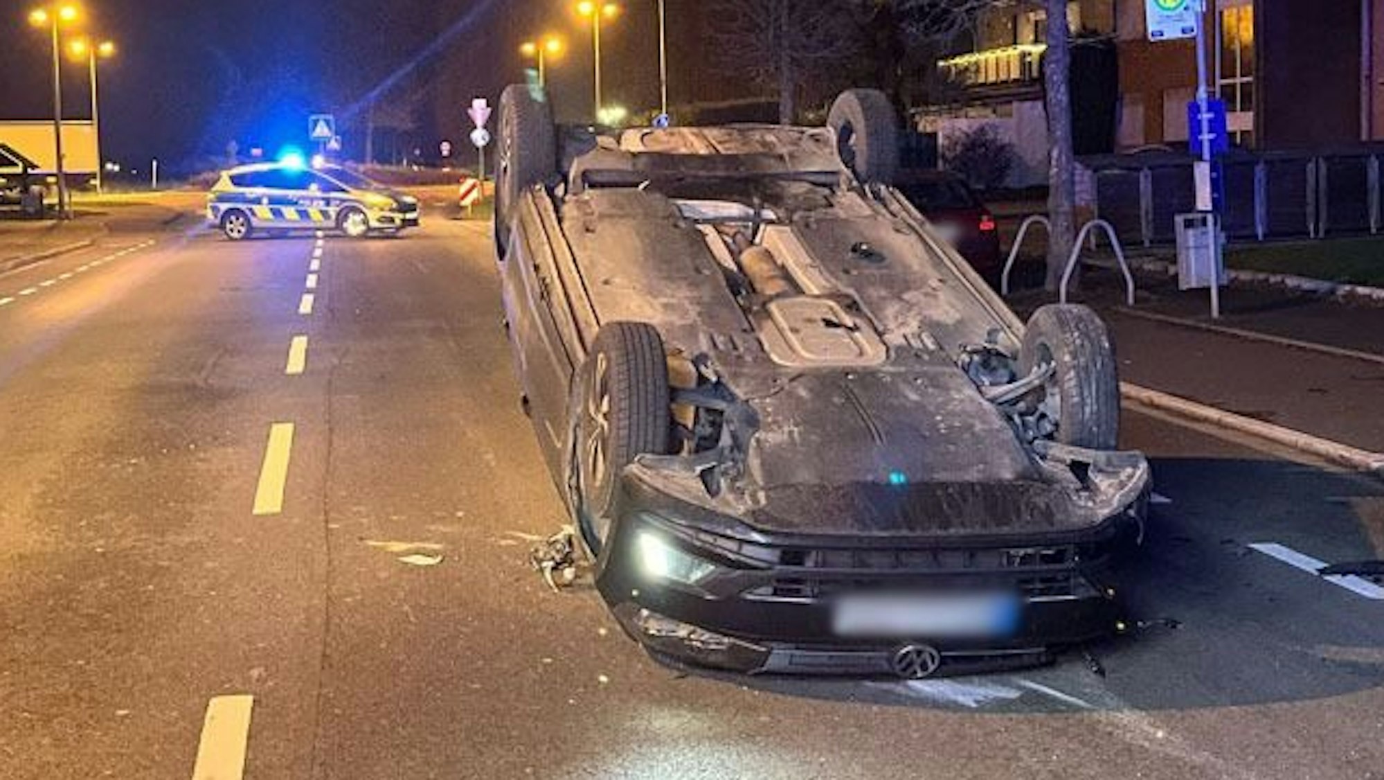Das Bild zeigt ein Auto, das auf der Glescher Straße in Bergheim-Paffendorf auf dem Wagendach liegt.