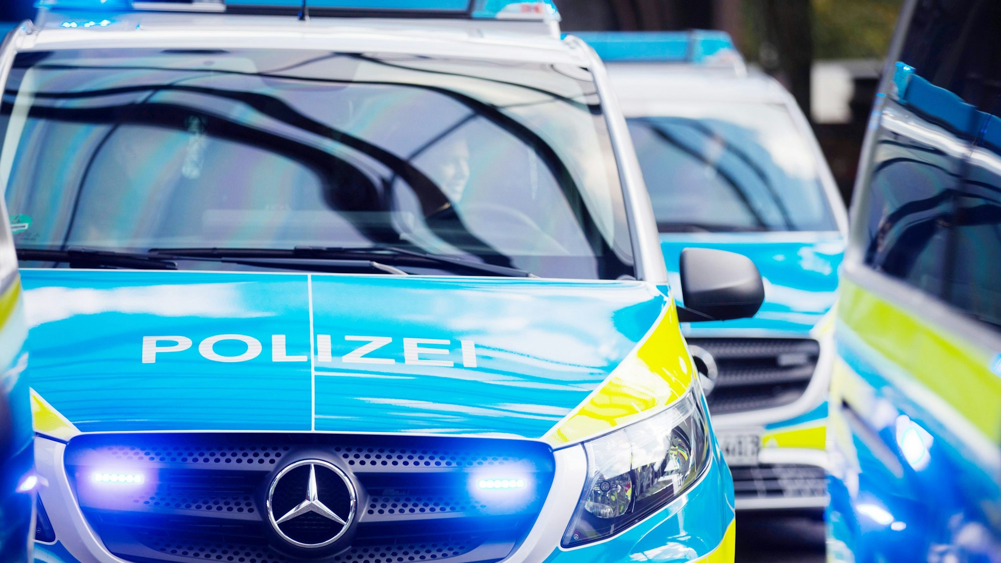 Das Foto zeigt mehrere Einsatzfahrzeuge der Polizei.